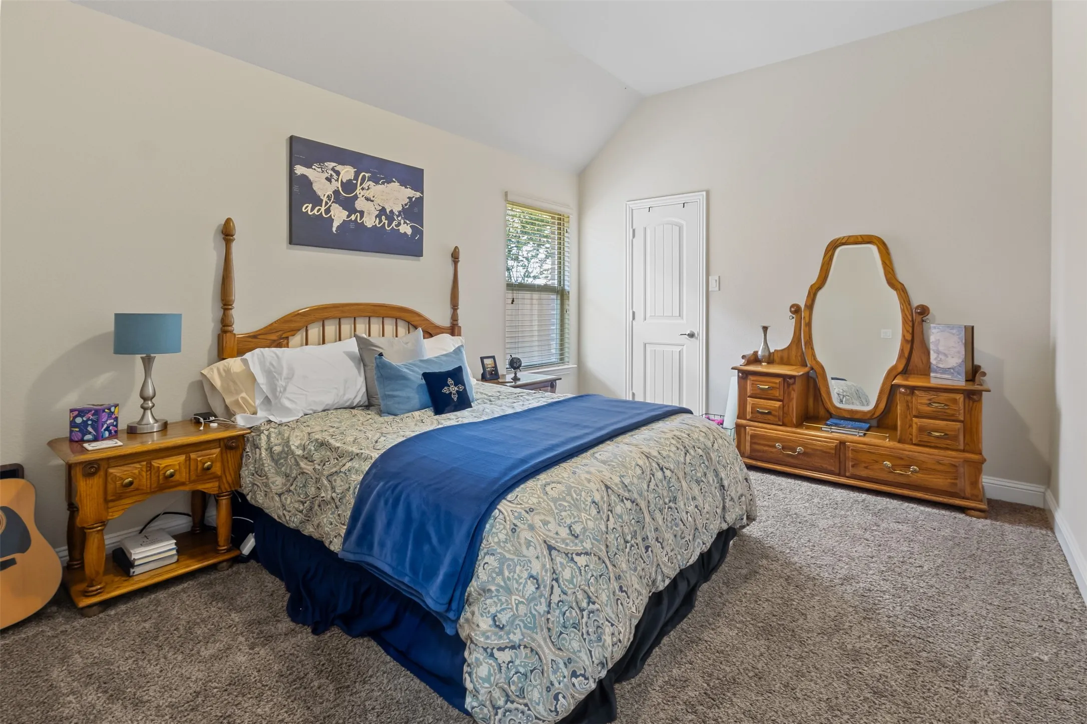 Vaulted ceiling with an arched window, soft neutral wall tones, and plush carpeting