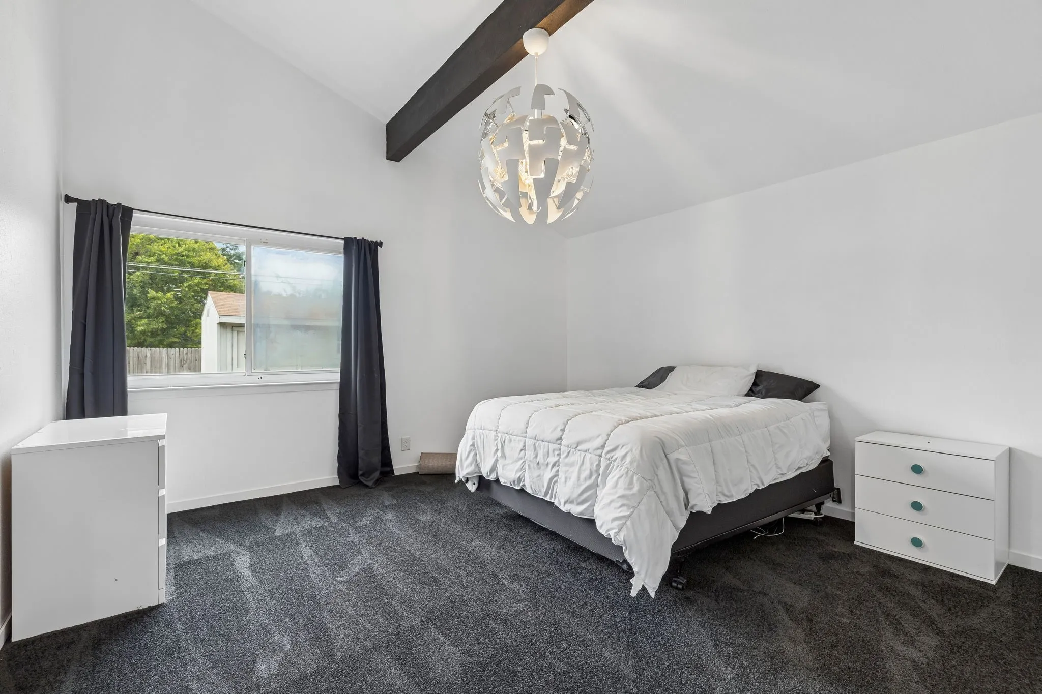 Primary bedroom with new carpet and a beautiful light fixture