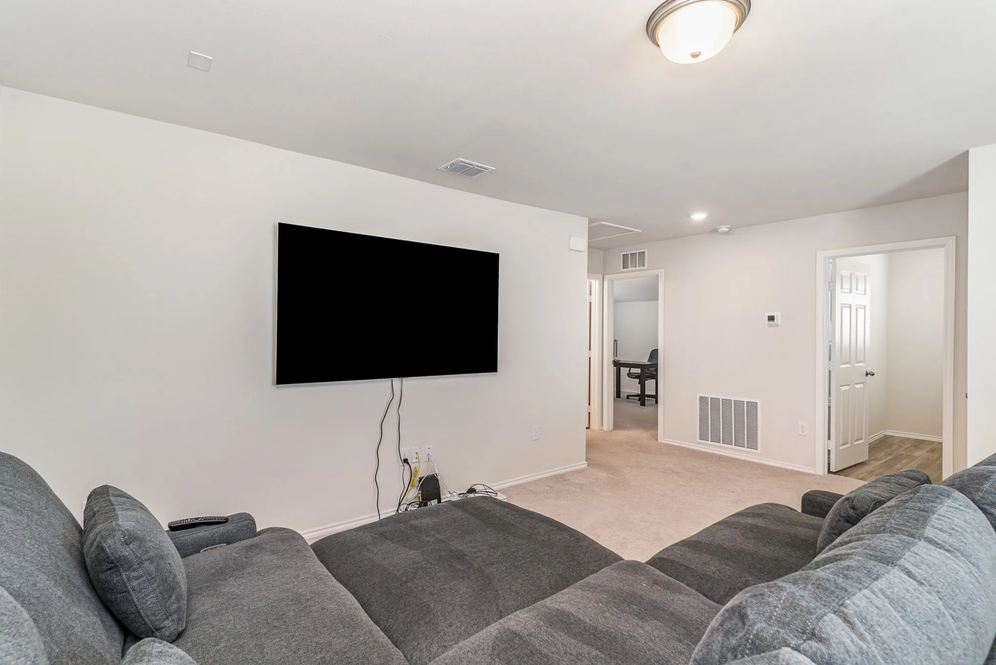 Carpeted room with recessed lighting and a flush-mount ceiling fixture