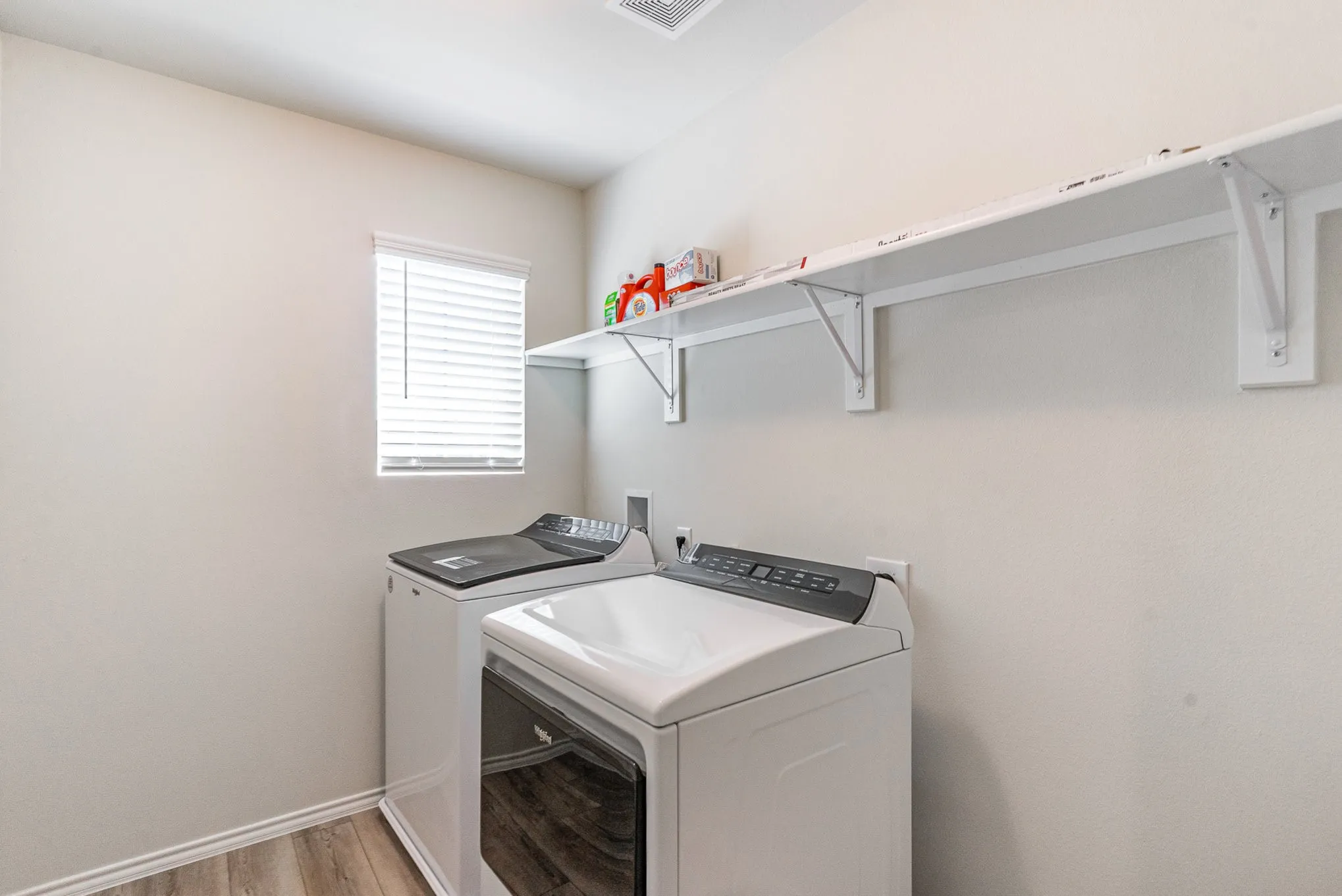 Wood-finish flooring with white walls and a white built-in shelf