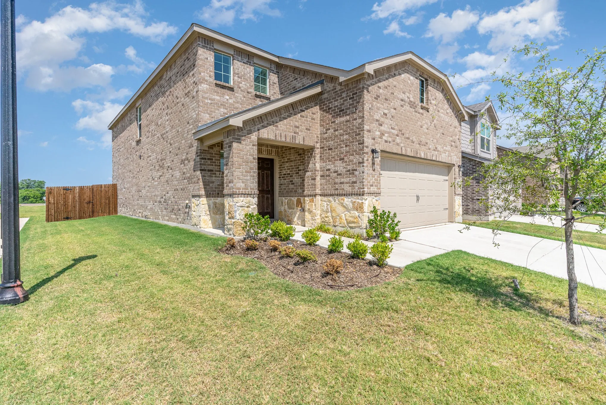 Brick exterior with stone accents, covered entry, and attached garage