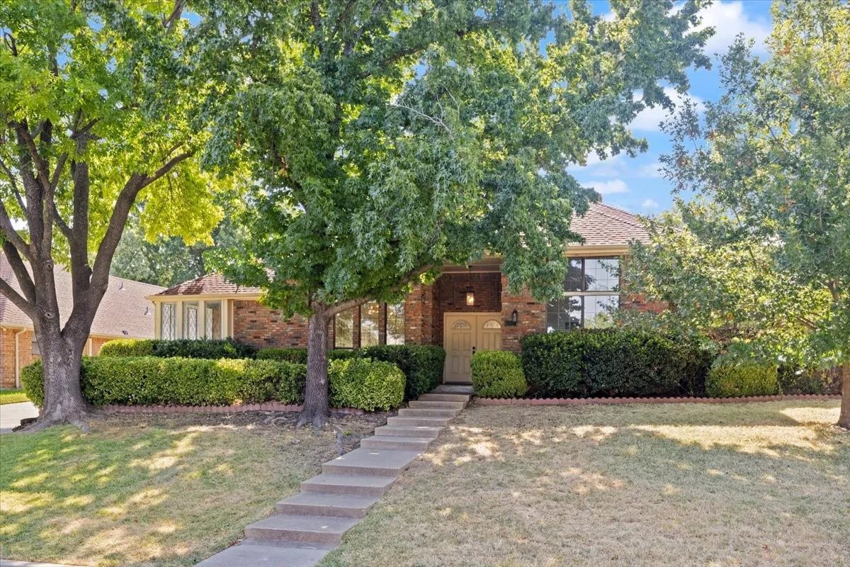 Brick exterior with a gabled roof and mature trees