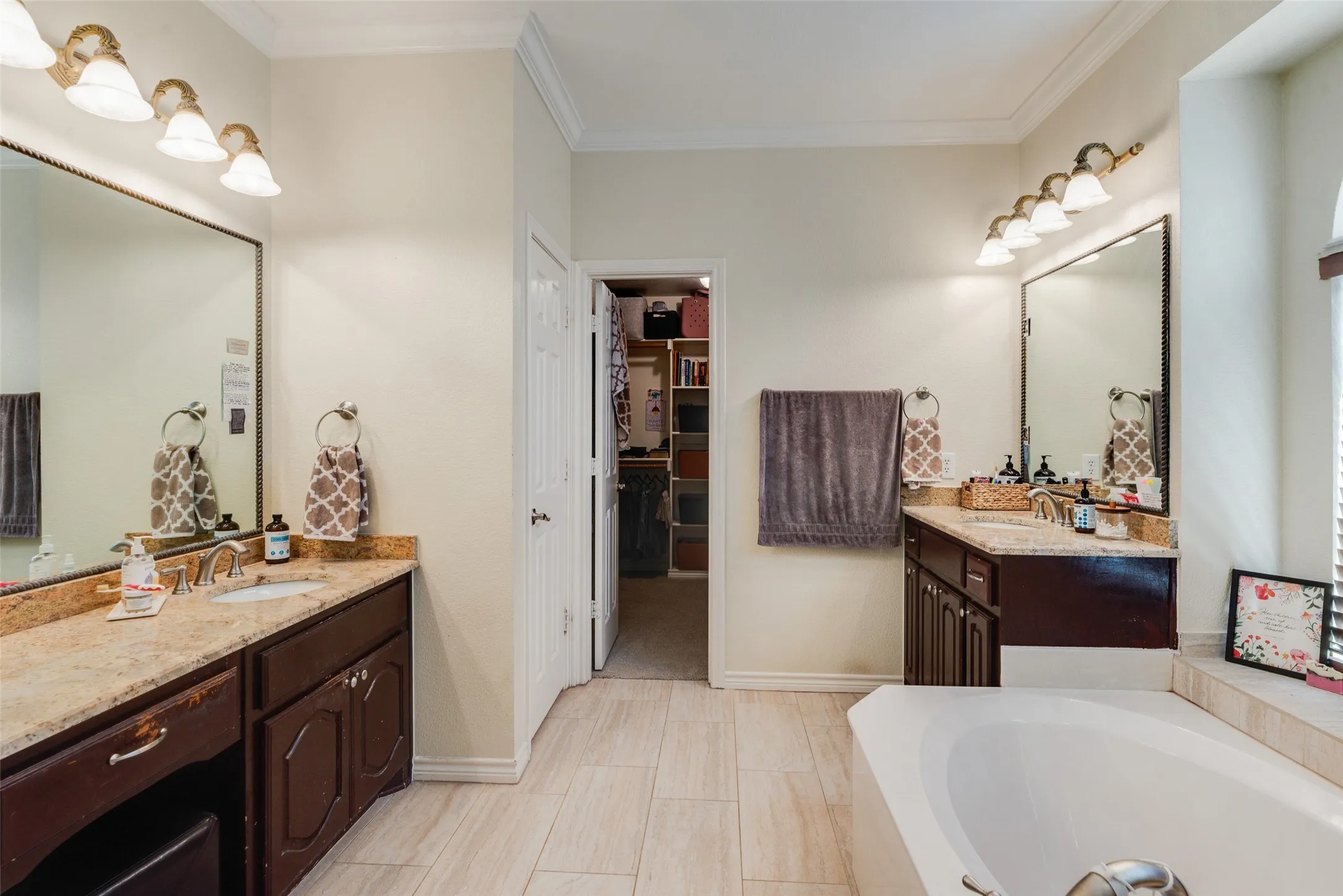 Dual vanity with wood-finish cabinetry and stone countertops