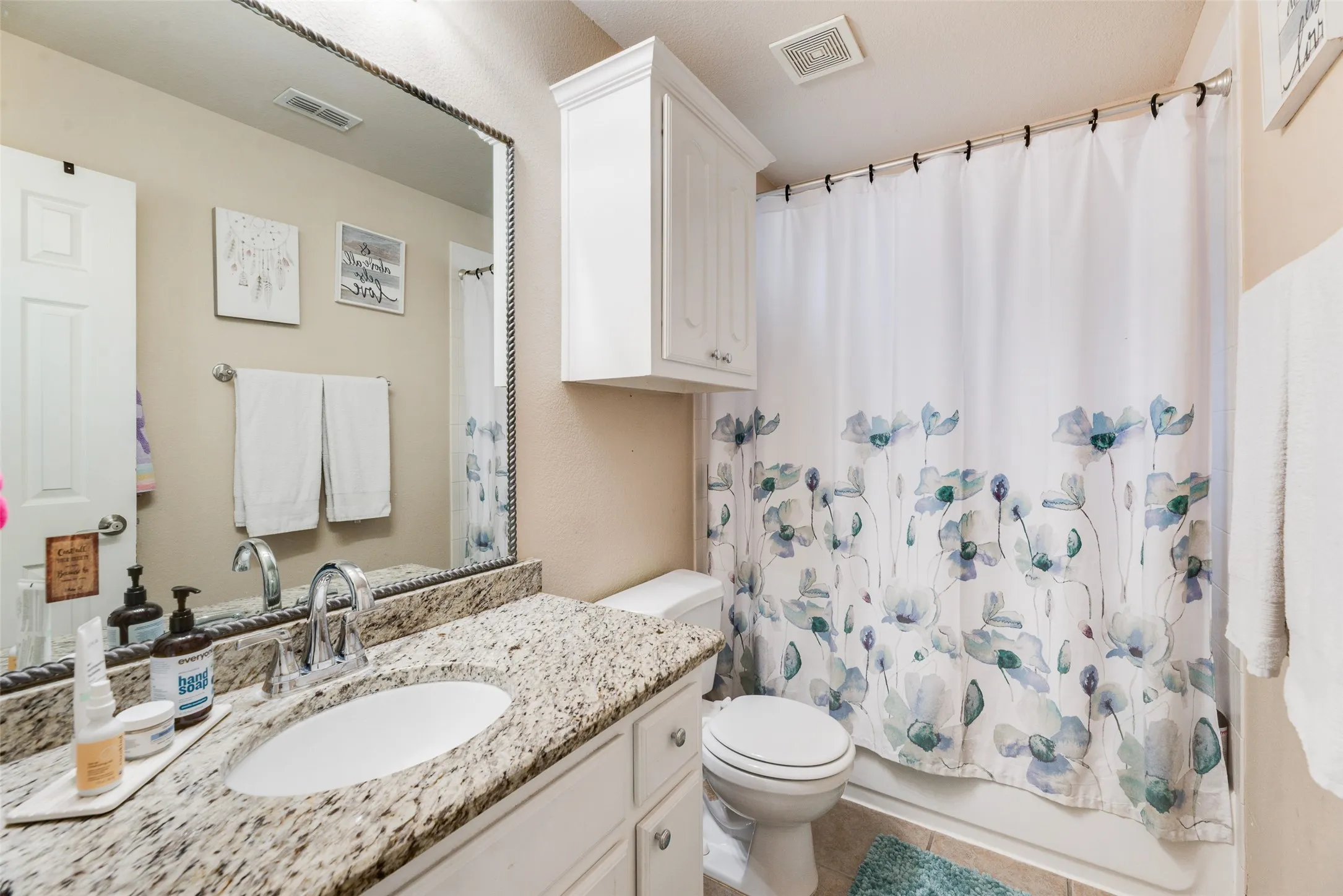 Built-in vanity with a granite countertop and an undermount sink