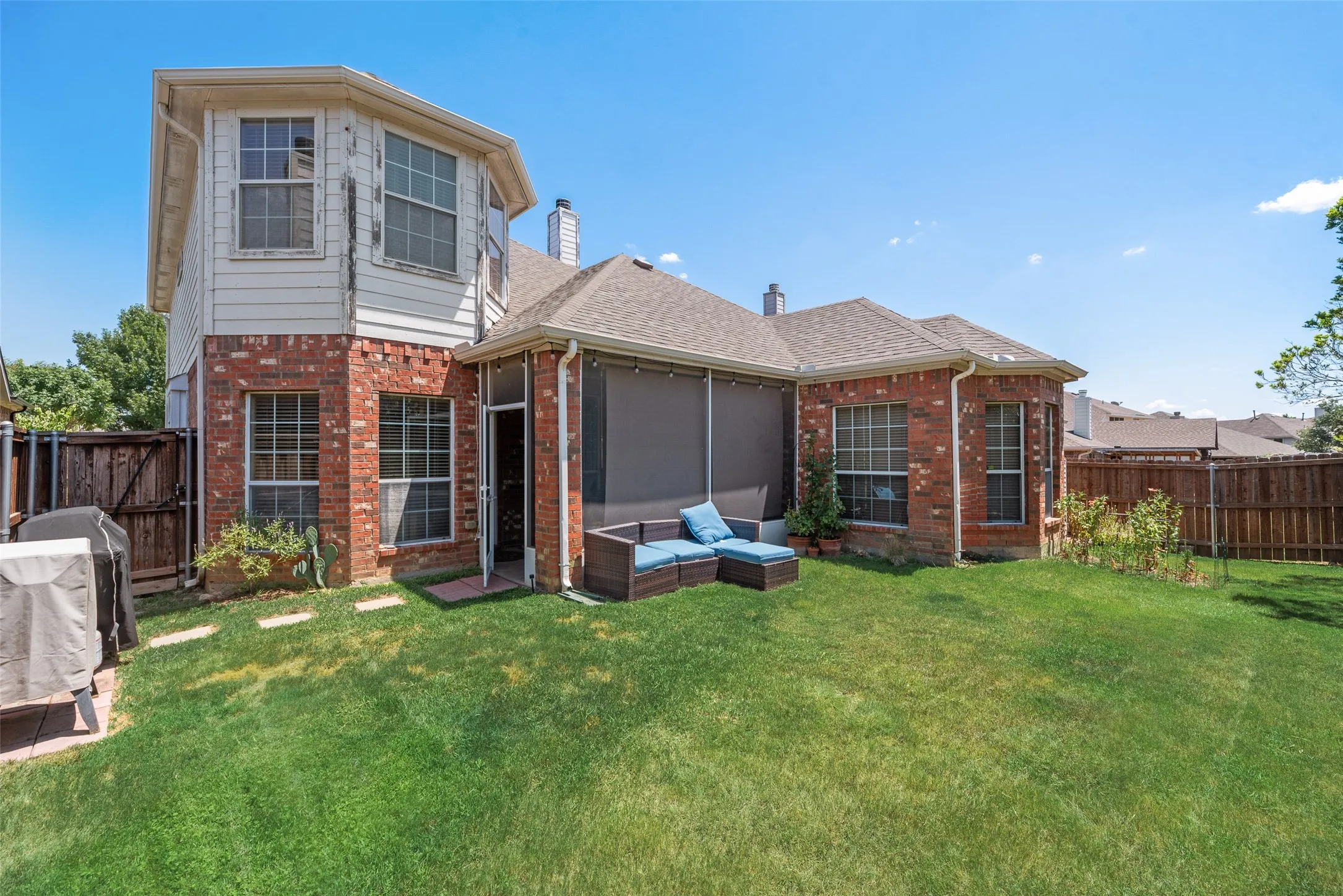 Brick and siding exterior, multi-pane windows, screened porch, fenced yard, and a shingle roof