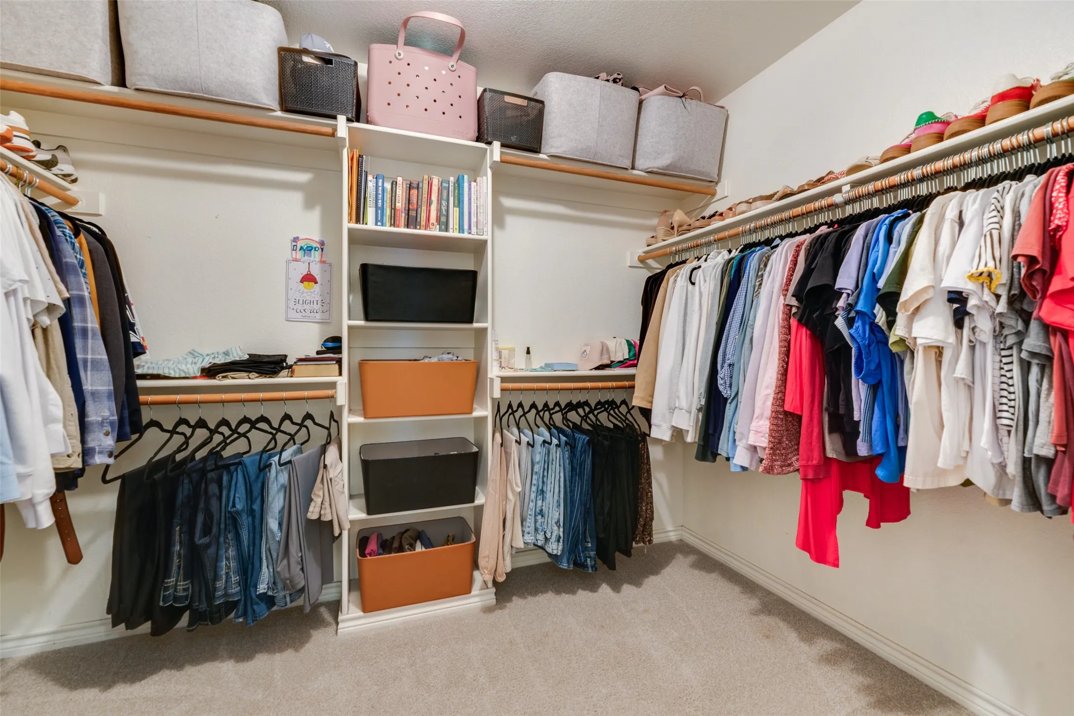 Custom closet system featuring built-in shelving, multiple hanging rods, and integrated storage