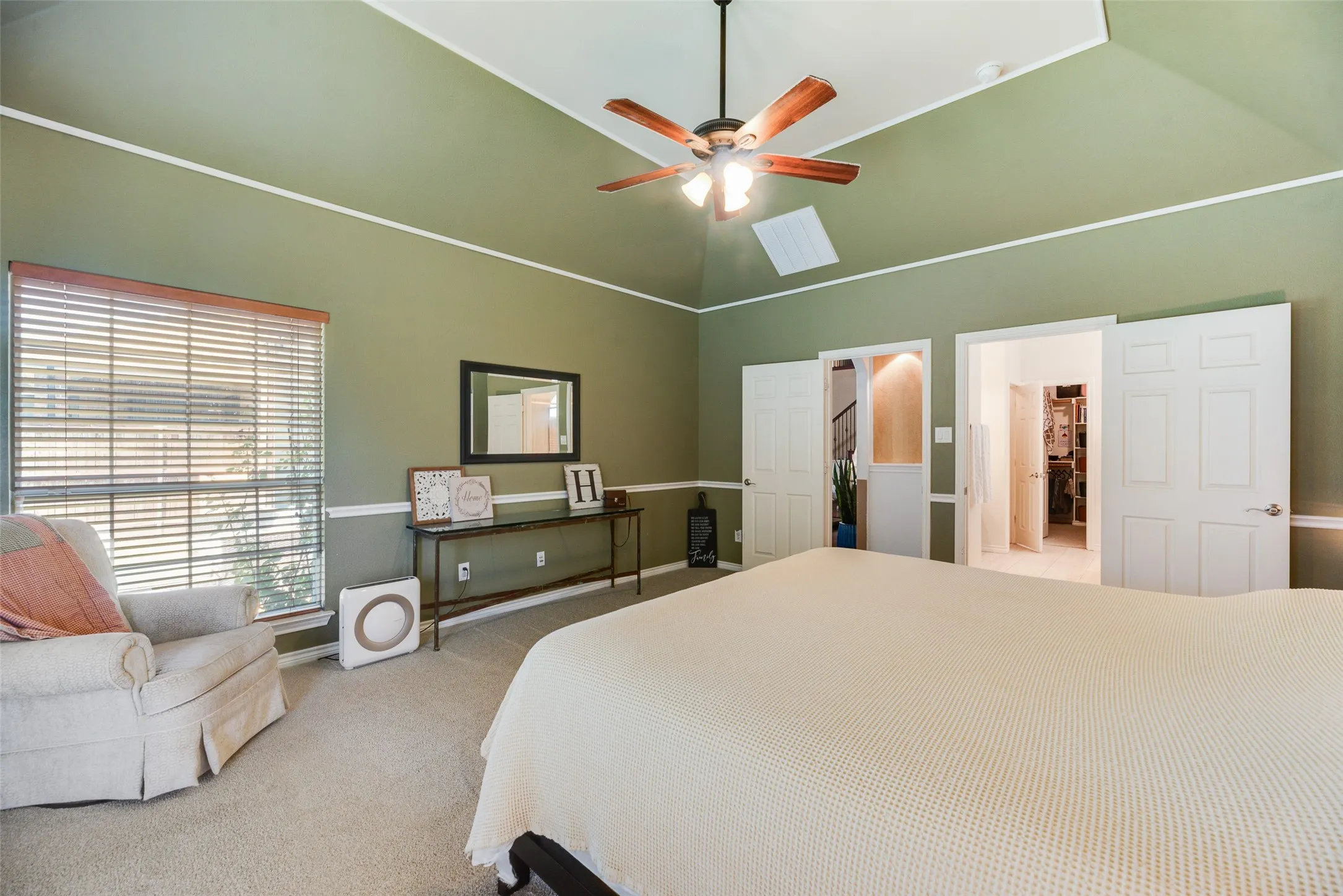 Tray ceiling with a ceiling fan, carpeted flooring, and a large window with blinds