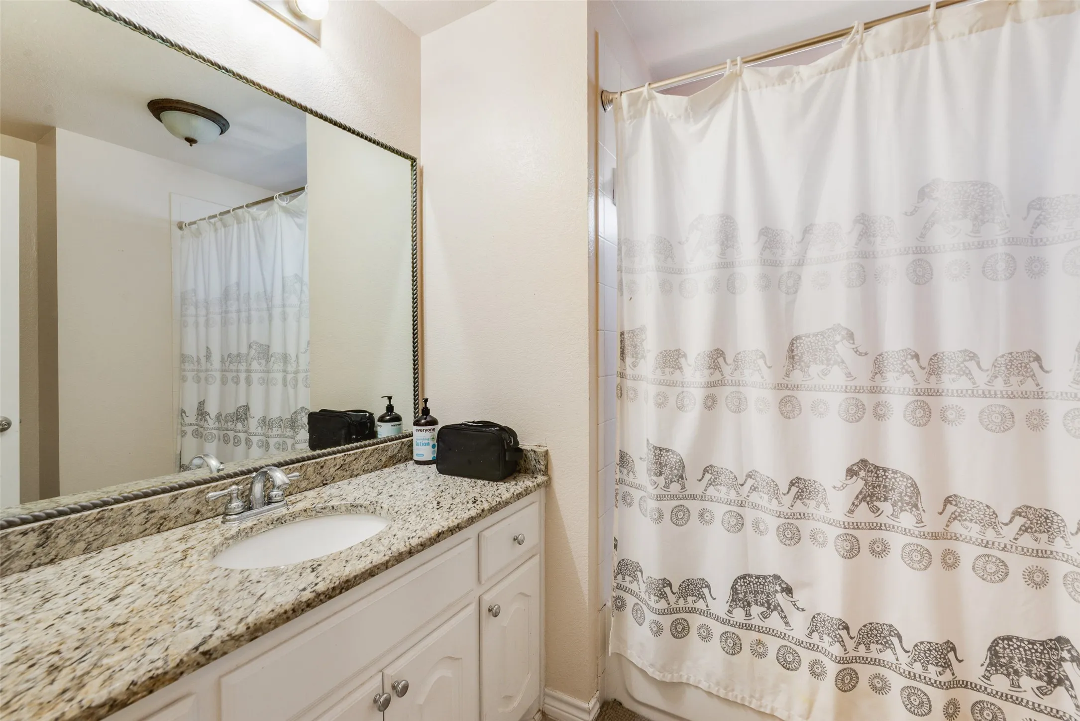 Vanity with a granite countertop, undermount sink, and chrome faucet