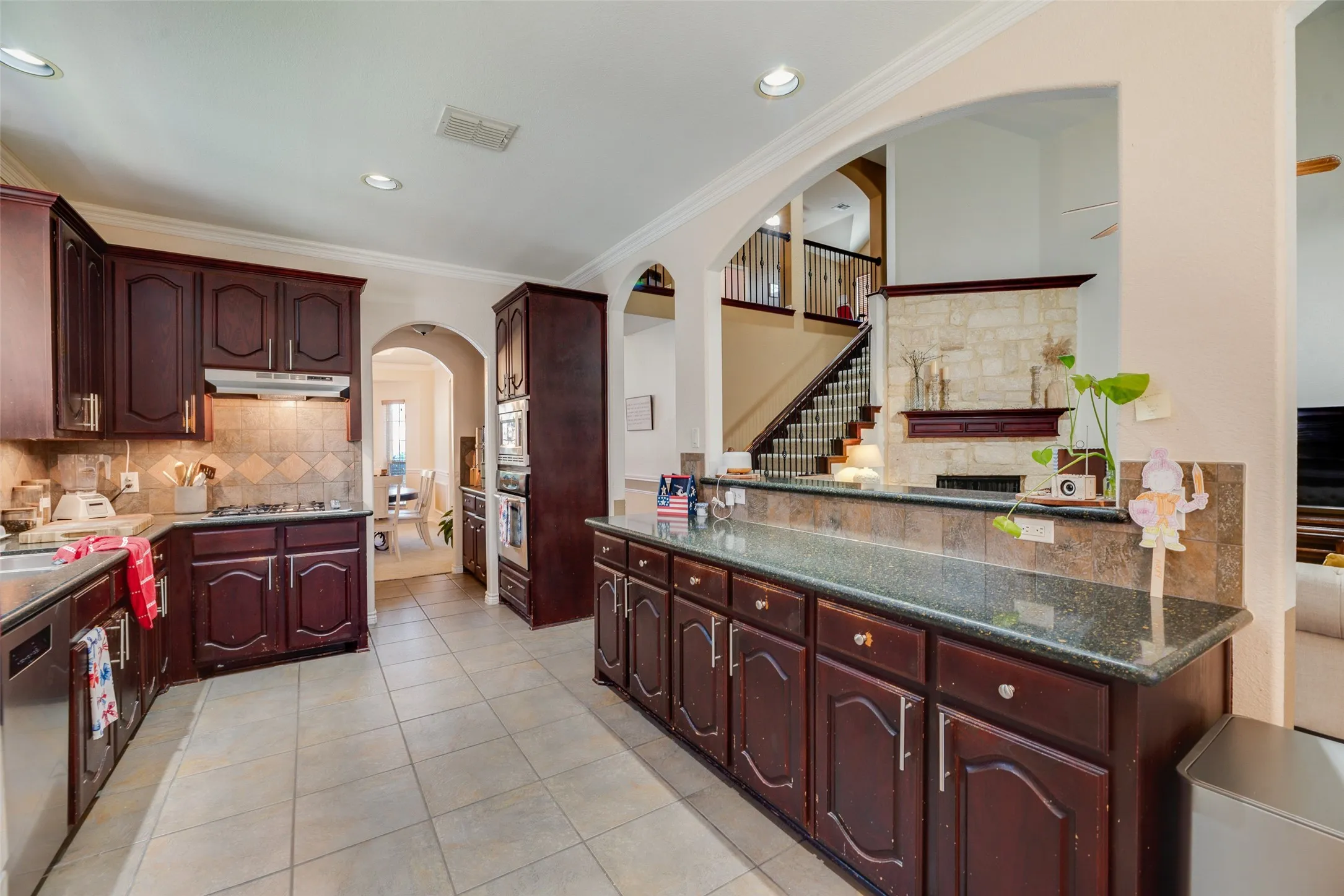 Kitchen with tile flooring, dark wood cabinetry, and recessed lighting