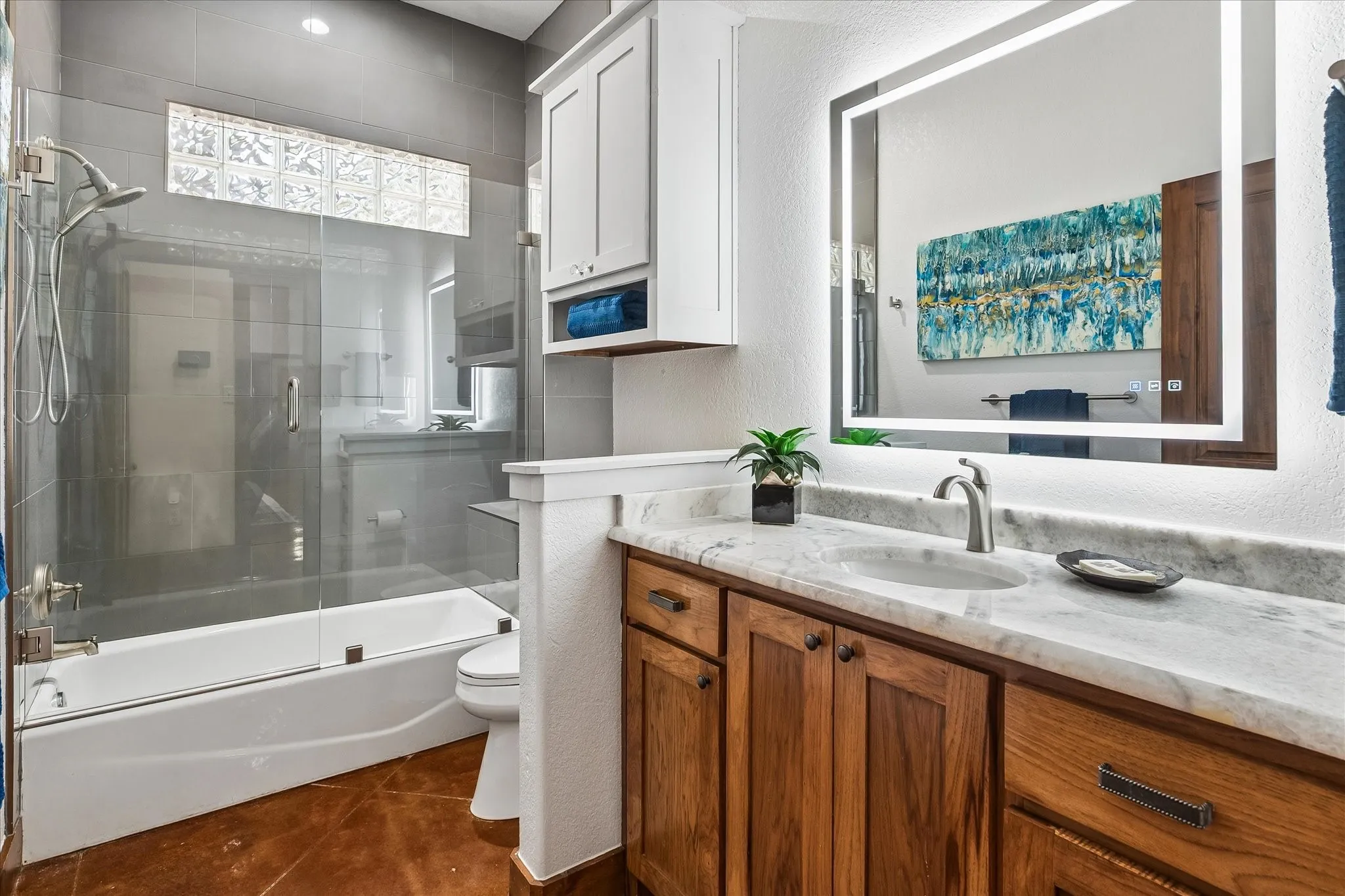 Wood-finish vanity with a stone countertop and an undermount sink