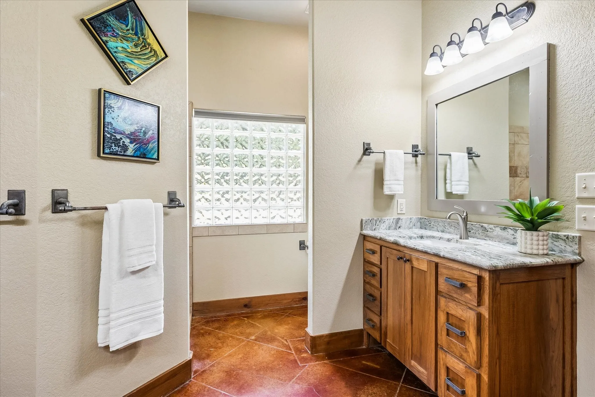 Wood-finish vanity with a stone countertop and integrated sink