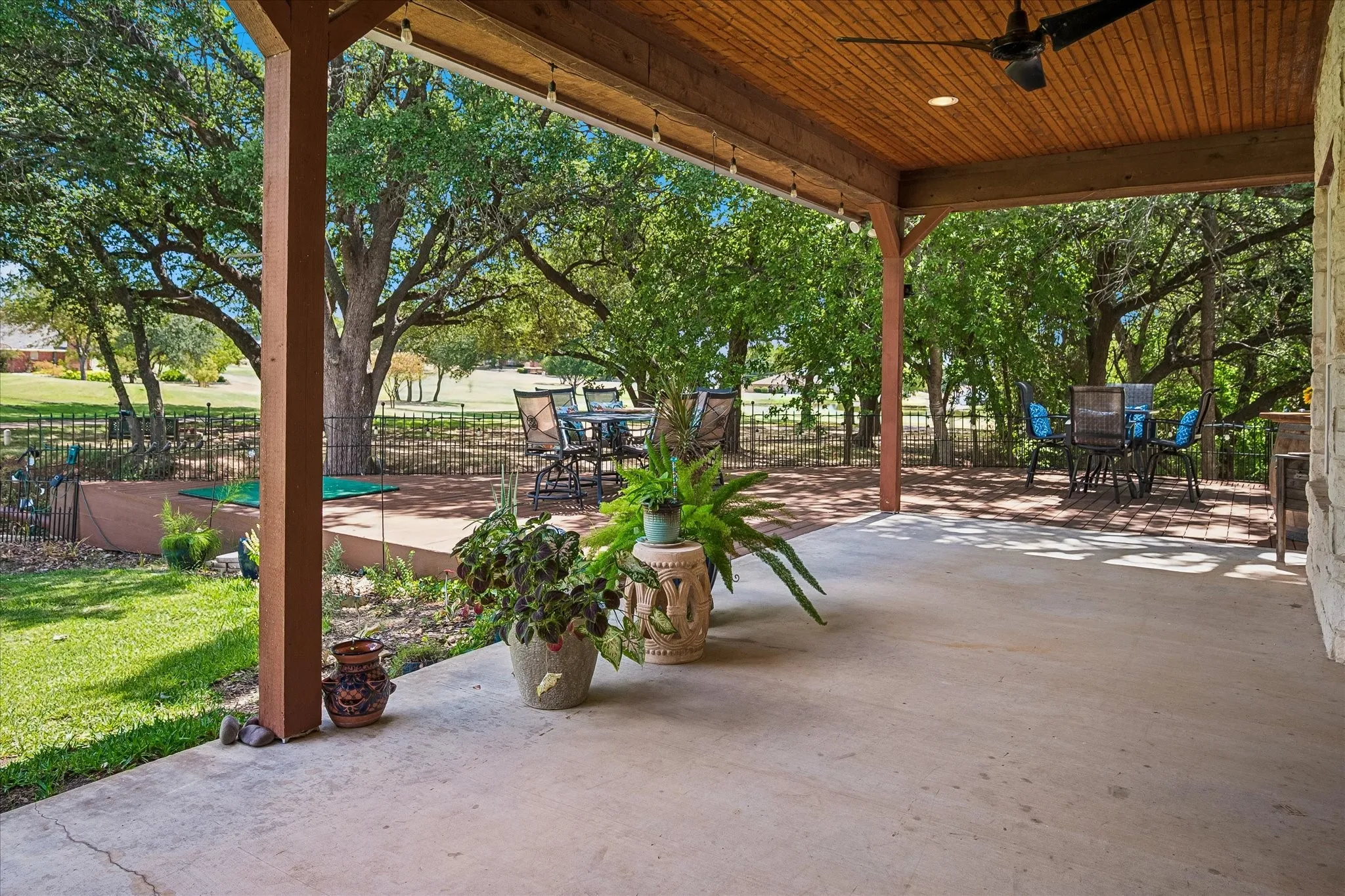 Expansive covered patio with a wood-plank
ceiling, recessed lighting, and a ceiling​​‌​​​​‌​​‌‌​‌‌​​​‌‌​‌​‌​‌​​​‌​​ fan