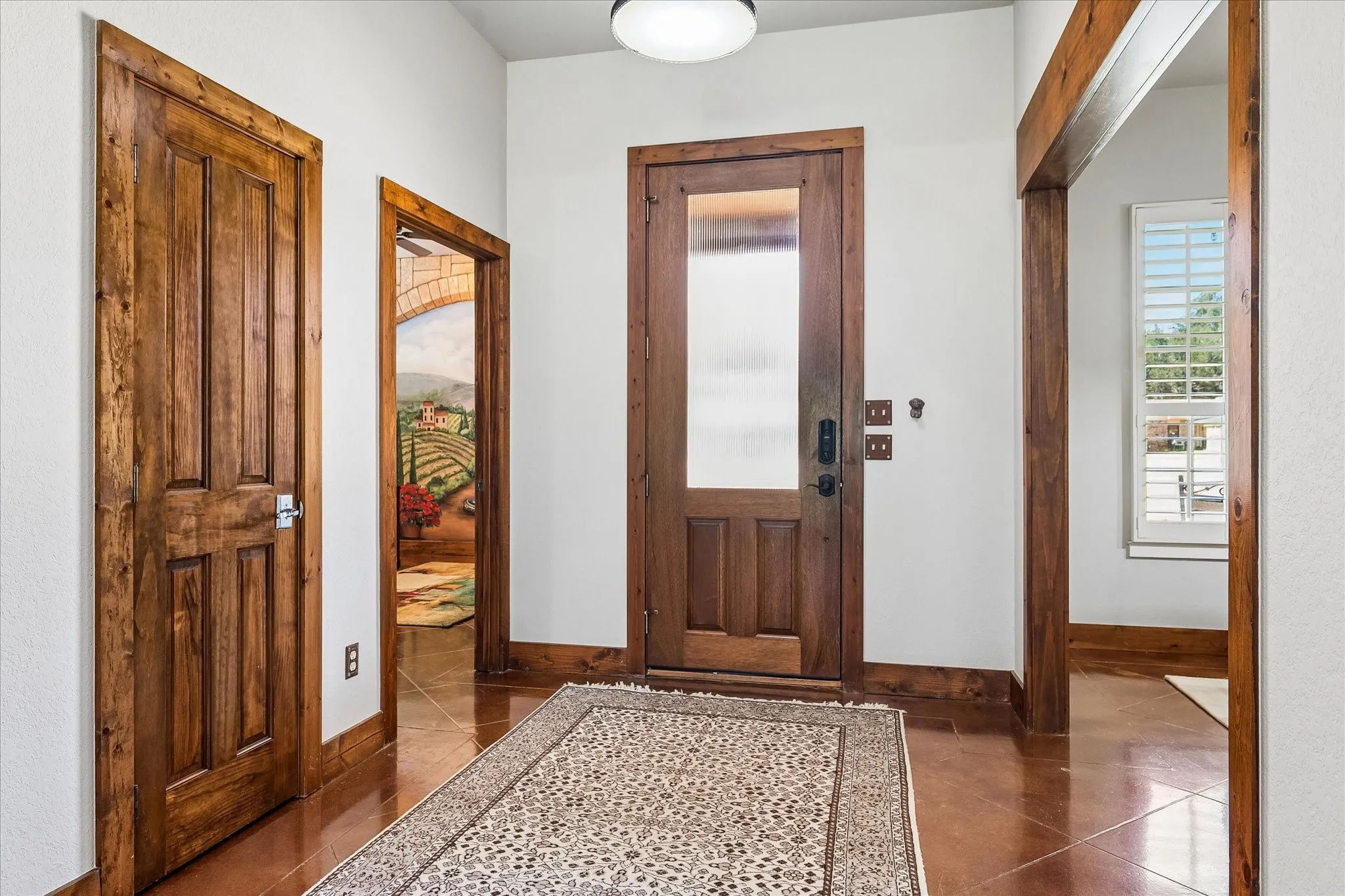 Hardwood doors with paneling, wood-finish trim, and tile flooring