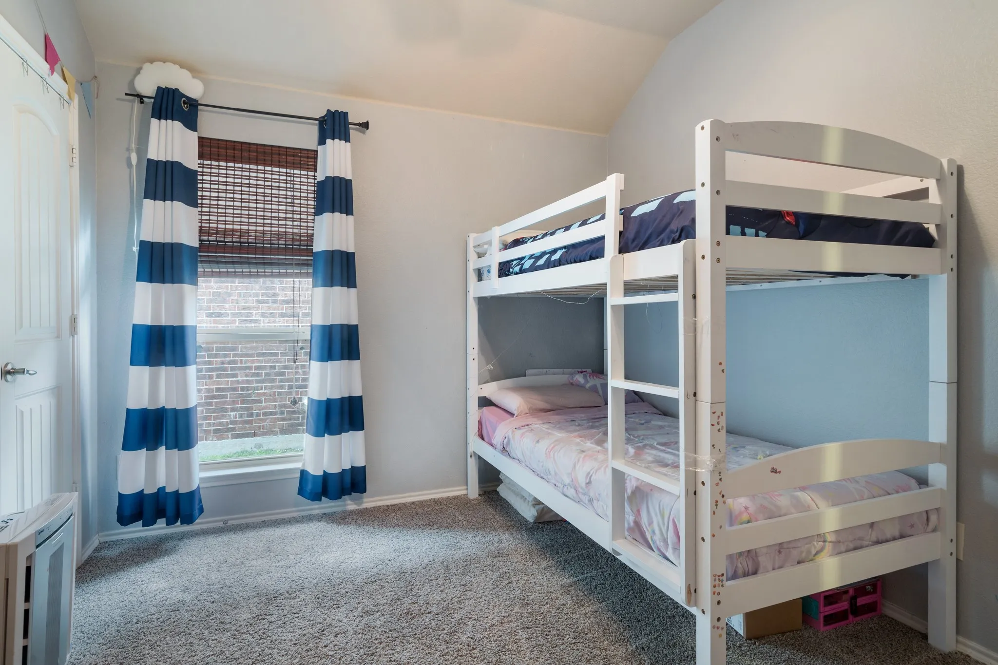 Carpeted room with a window featuring horizontal blinds, a paneled door, and a textured wall finish