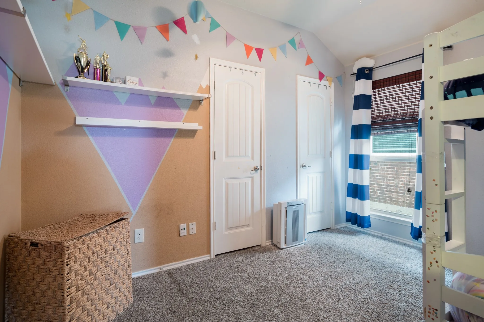 Carpeted room featuring two white paneled doors, built-in shelving, and a window with blinds