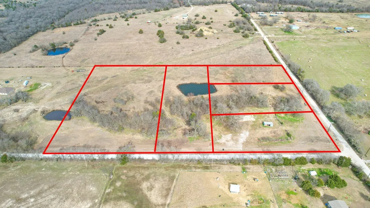 Expansive undeveloped land featuring multiple plots, natural water features, and an unpaved road access