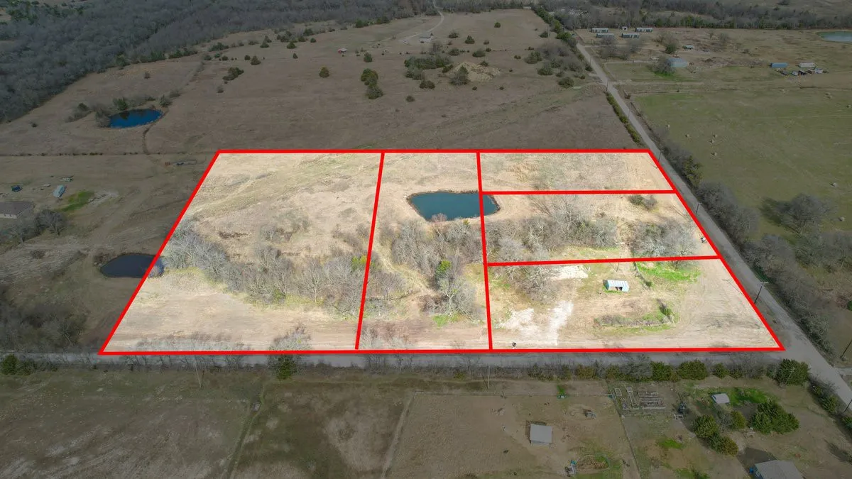 Expansive land parcel featuring multiple sections, a natural pond, a small structure, and mature tree coverage
