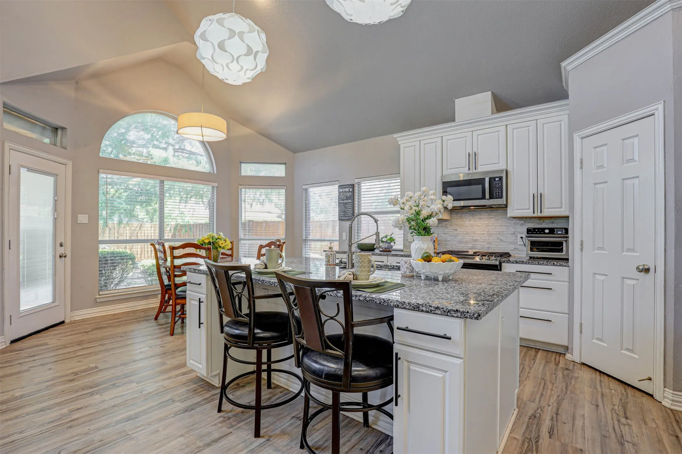 The kitchen impresses with an oversized island, breakfast bar, and abundant cabinetry — a perfect blend of style and storage.
