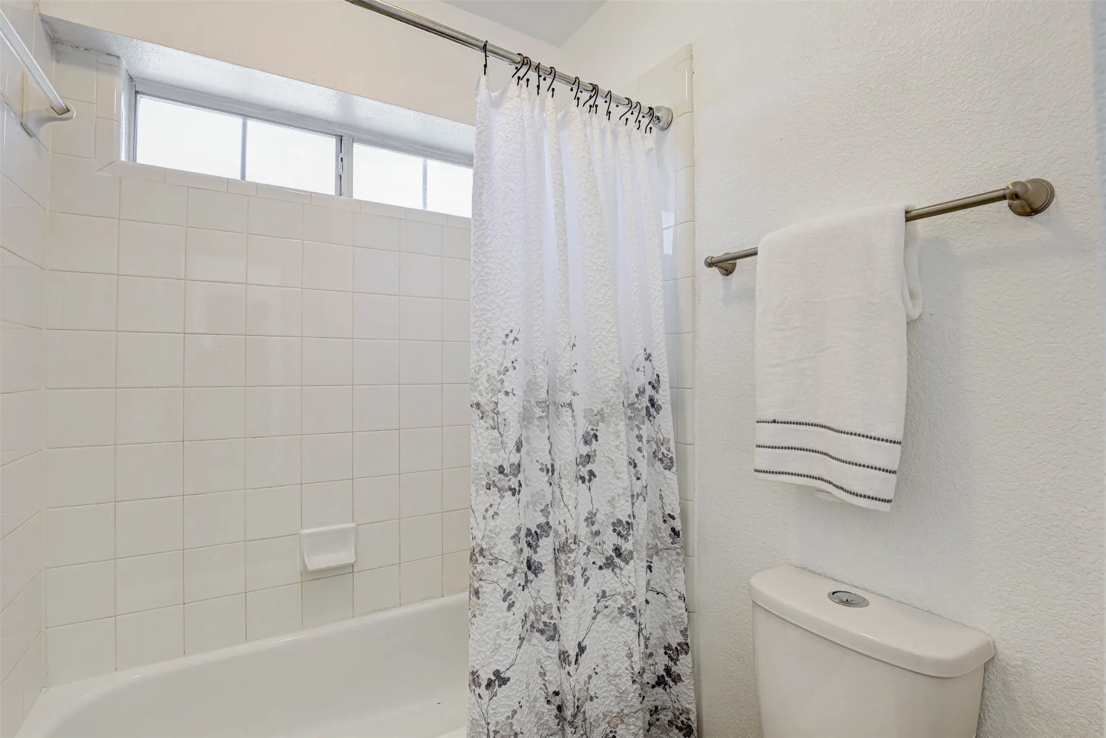 The shared wet area features a tub/shower combo and toilet, thoughtfully designed for easy access from both vanities.