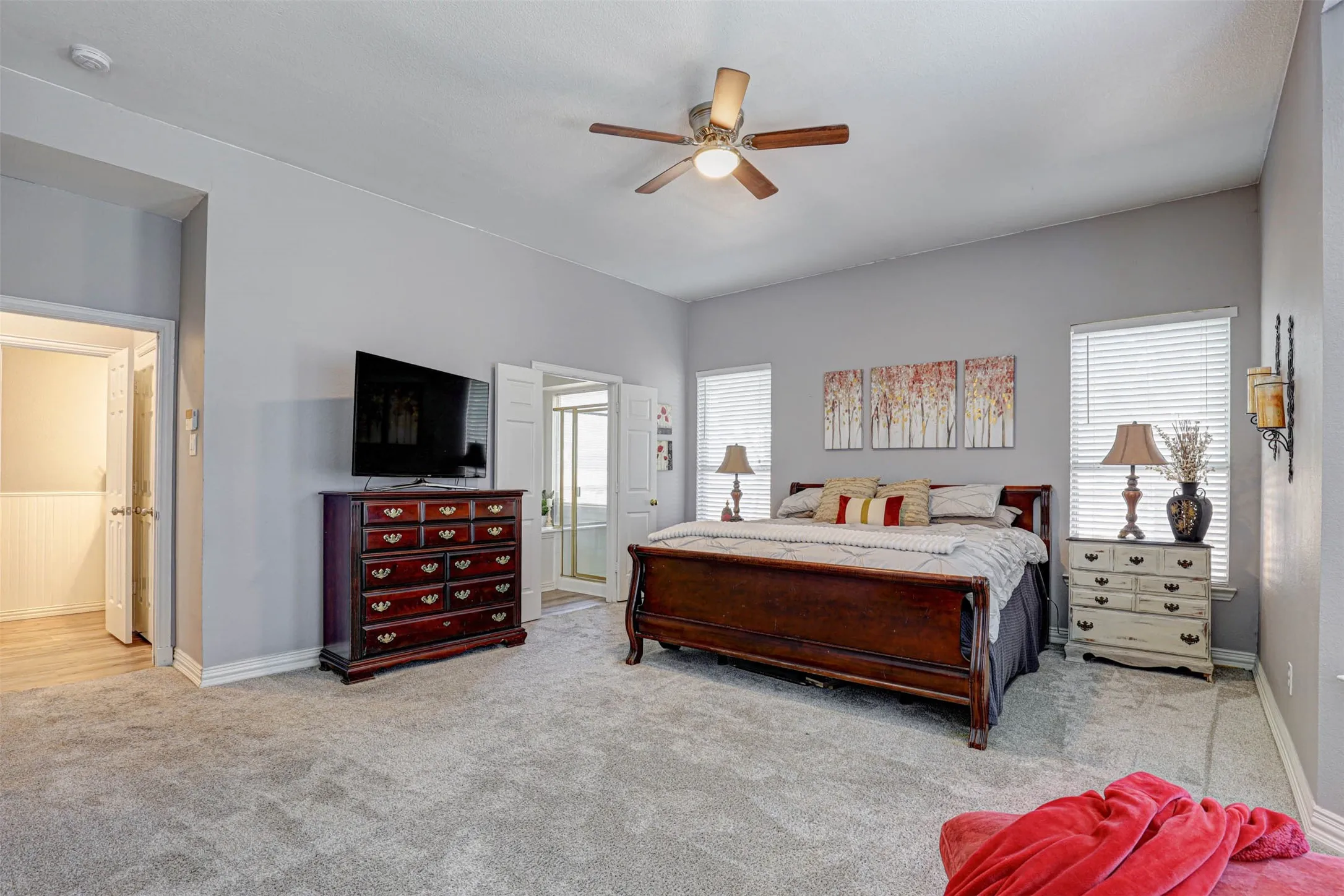 A spacious and serene primary suite with ceiling fan, offering the perfect peaceful retreat.