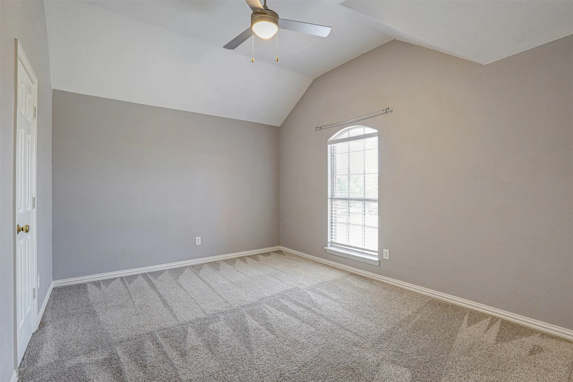 Bright and inviting upstairs bedroom with walk-in closet and ceiling fan, offering a comfortable private retreat.