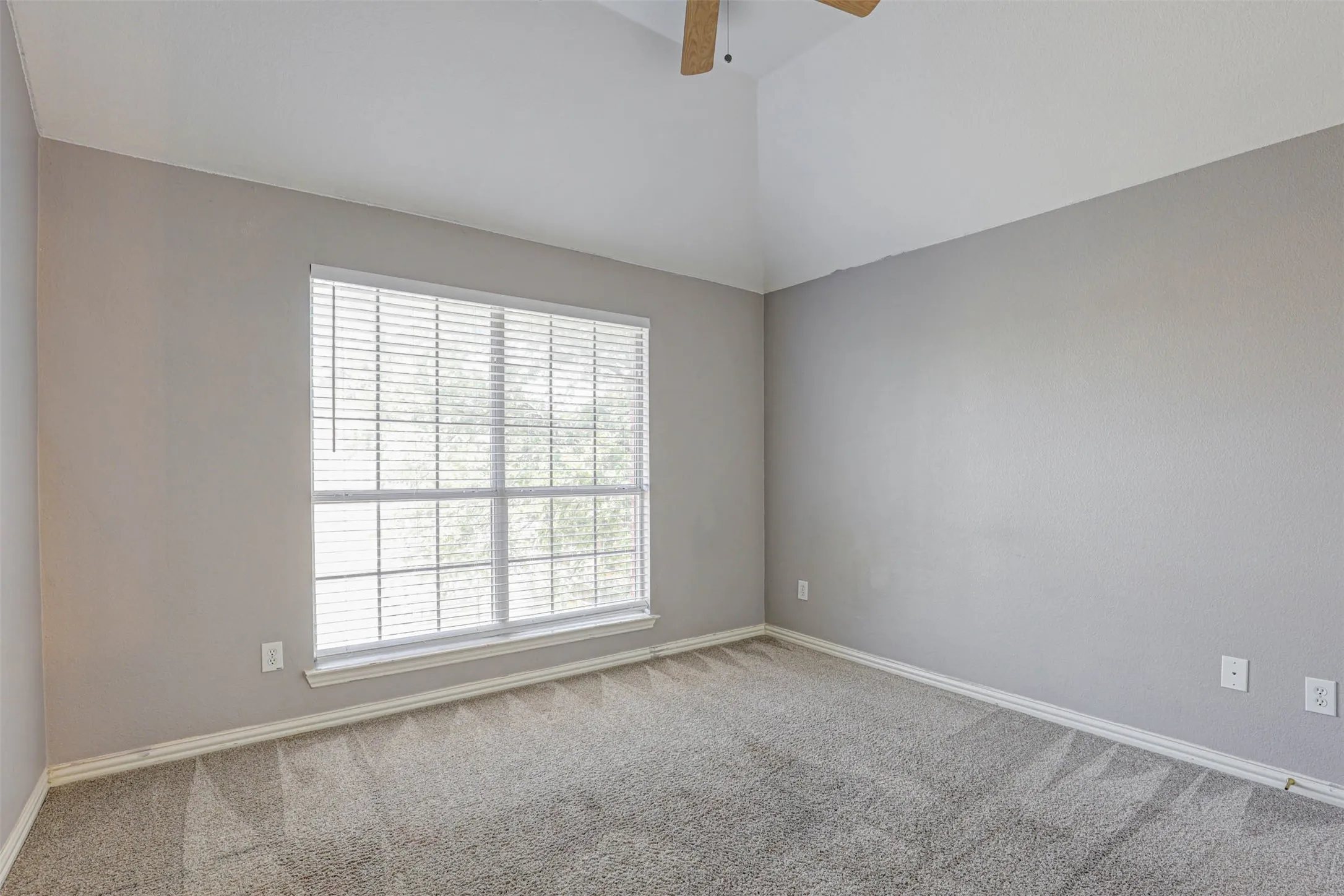 A comfortably sized upstairs bedroom with walk-in closet and ceiling fan — a cozy space for rest and relaxation.
