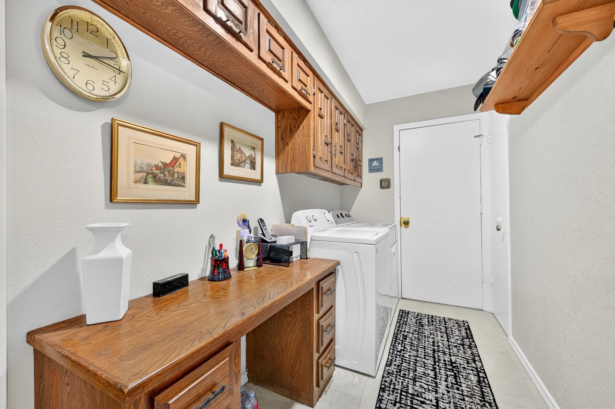 Laundry room with built in desk and cabinets