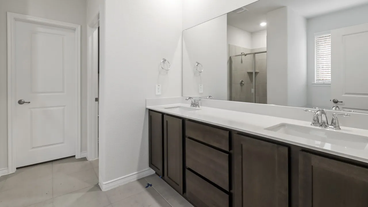 Double vanity with white countertops, undermount sinks, and chrome faucets