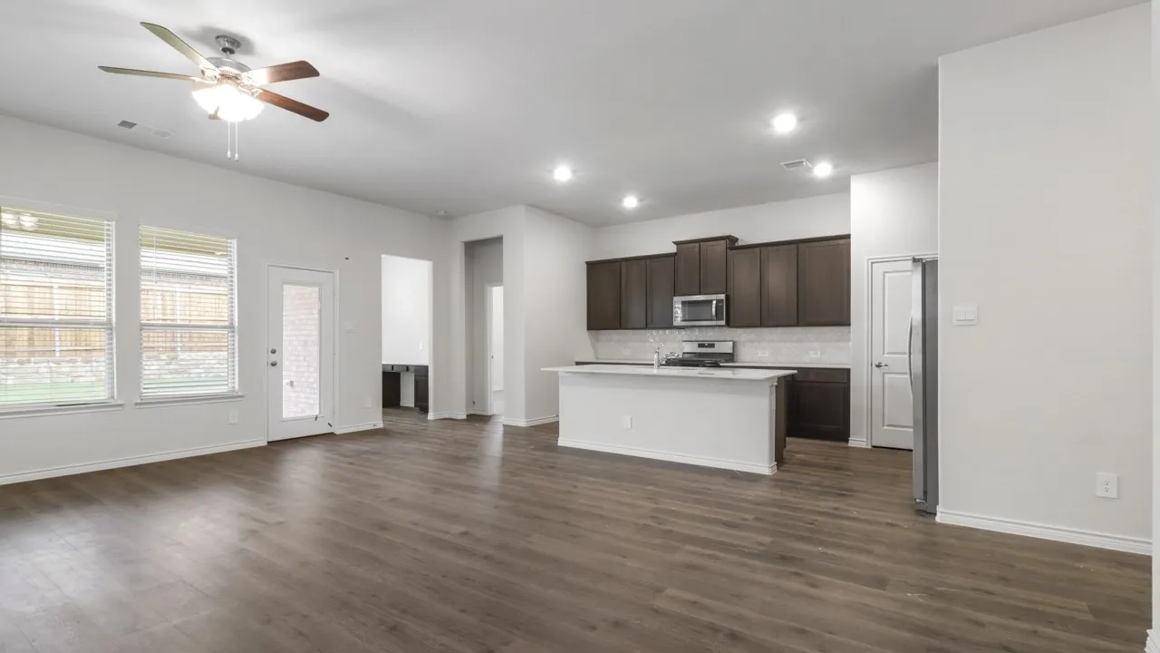 Open-concept living area with wood-finish flooring, recessed lighting, and a ceiling fan