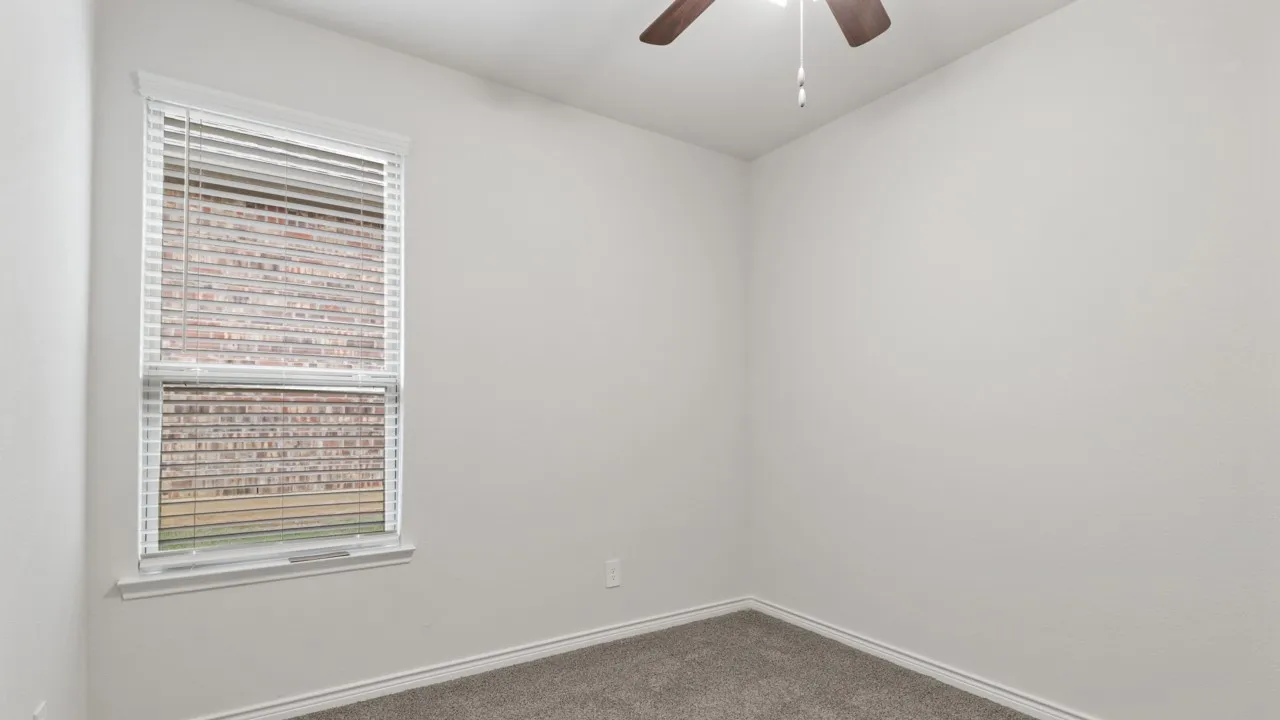 White walls with textured finish, window with white blinds, dark gray carpet, and a ceiling fan