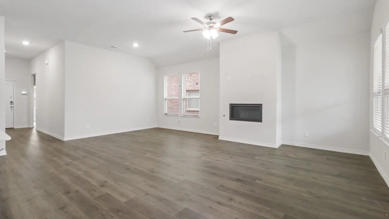Spacious room featuring wood-finish flooring, recessed lighting, a ceiling fan, and a built-in fireplace