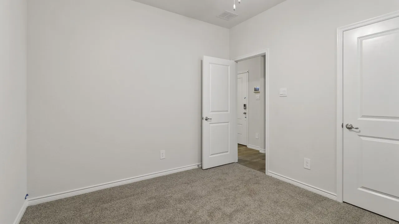 Light gray carpeted flooring paired with white walls, white trim, and white panel doors