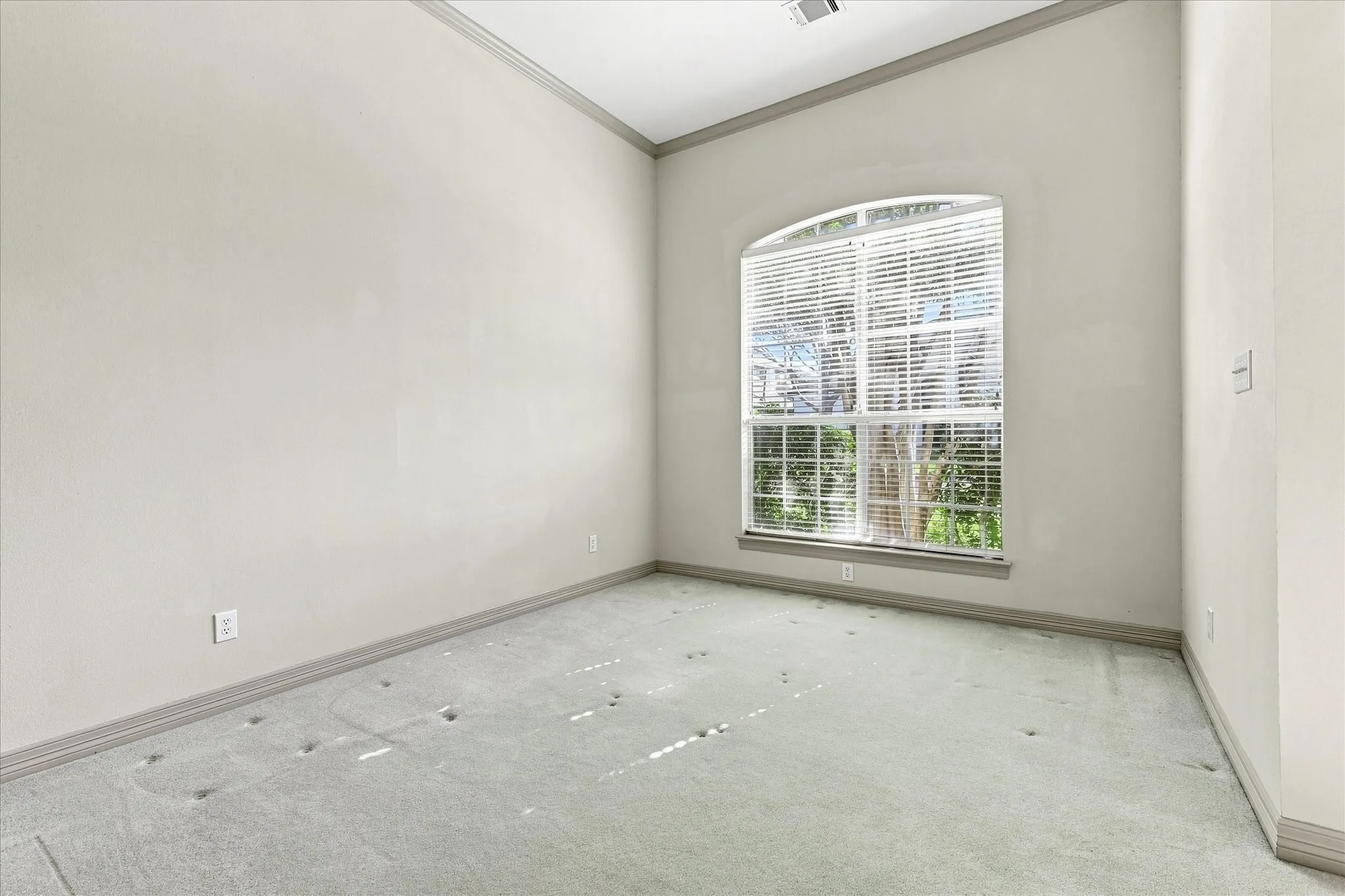 Arch-top window with blinds in third bedroom and ensuite access to jack and jill bathroom