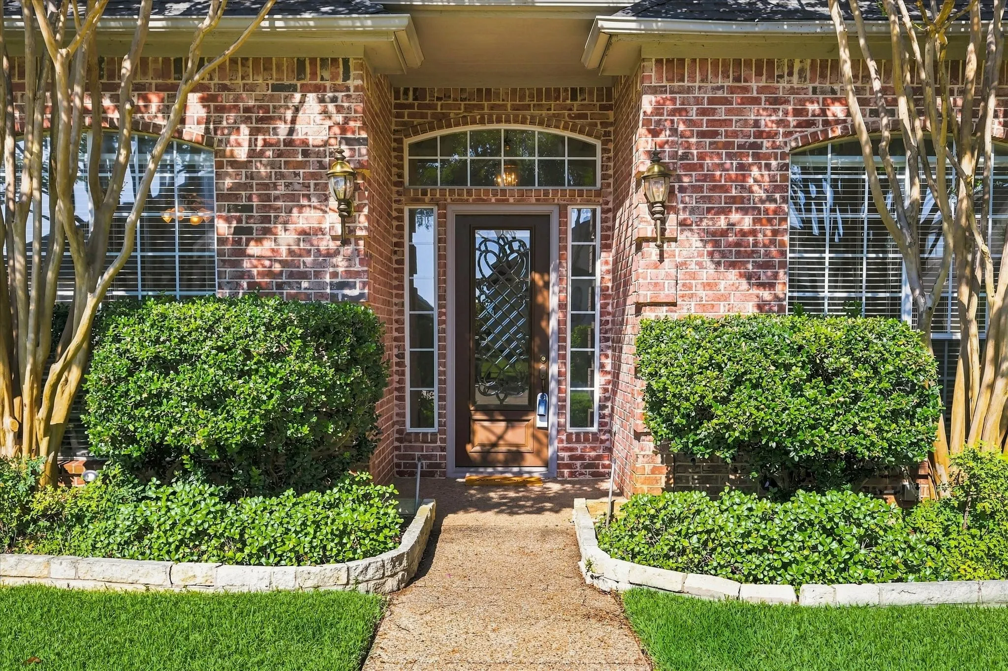Elegant entry with arched transom window above the beveled, leaded glass front door