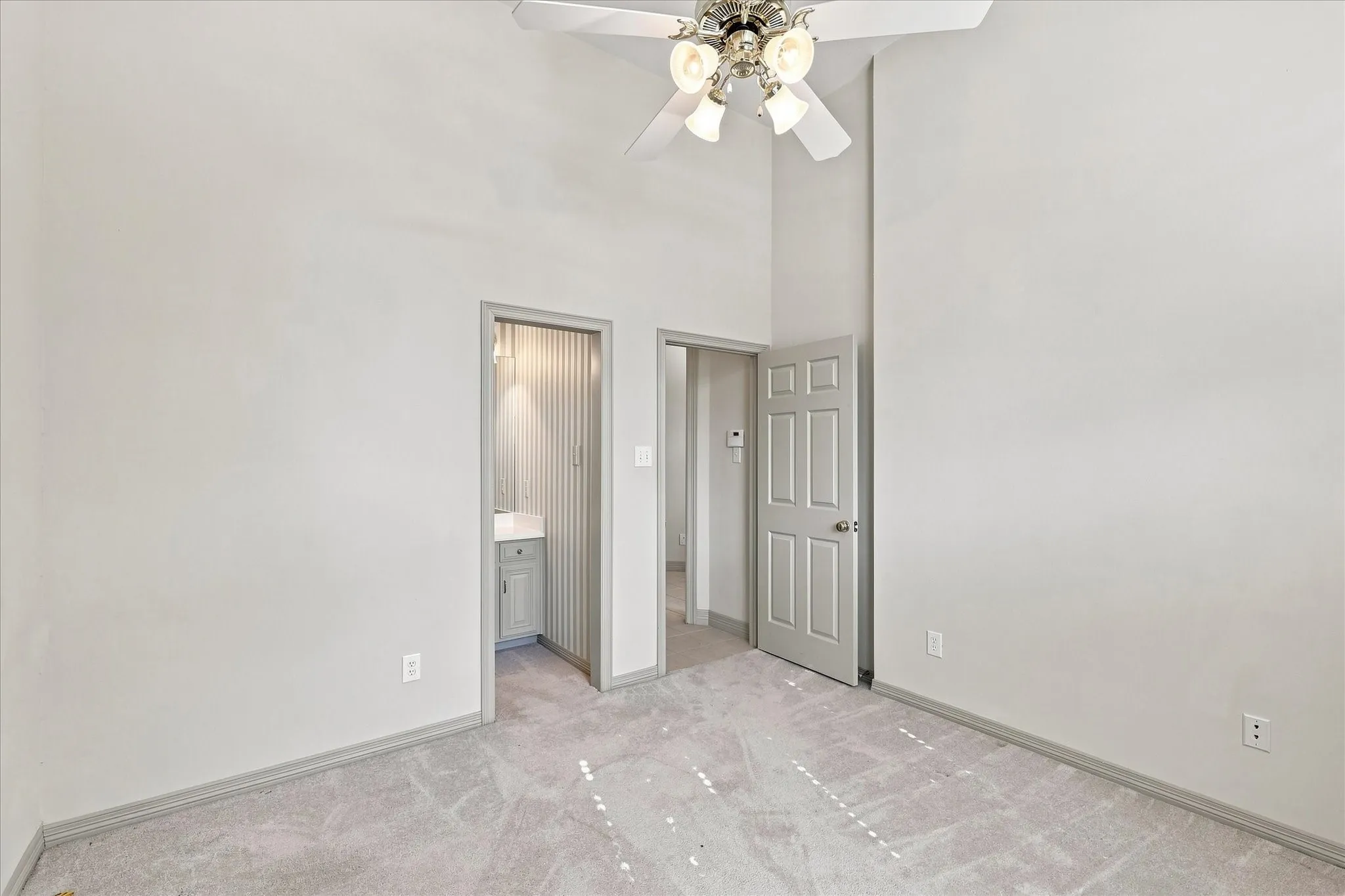 Bedroom door to a built-in vanity, with sunlight through blinds
