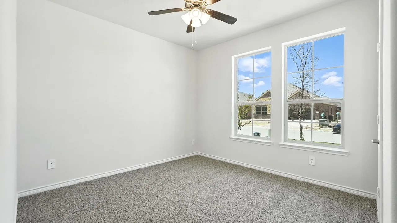 Neutral wall paint, ceiling fan with light fixture, gray carpet, and dual windows
