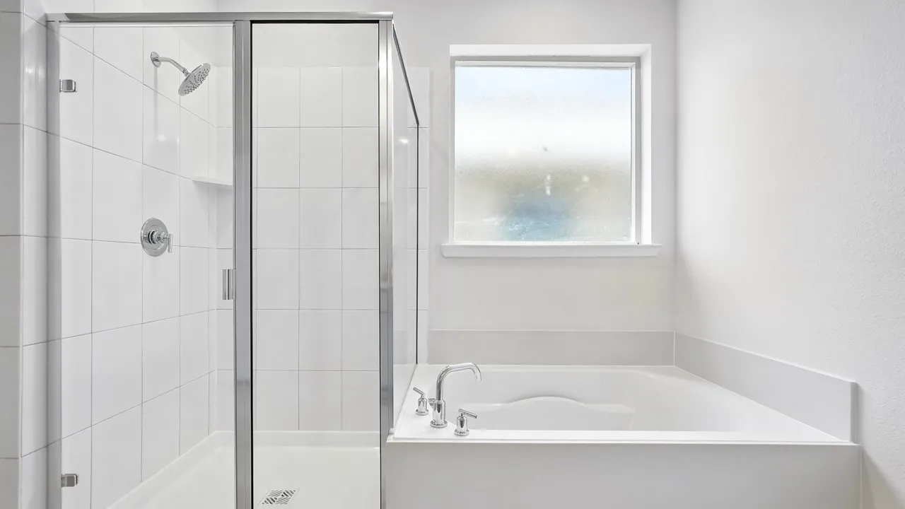 Walk-in shower with clear glass enclosure and tile surround
