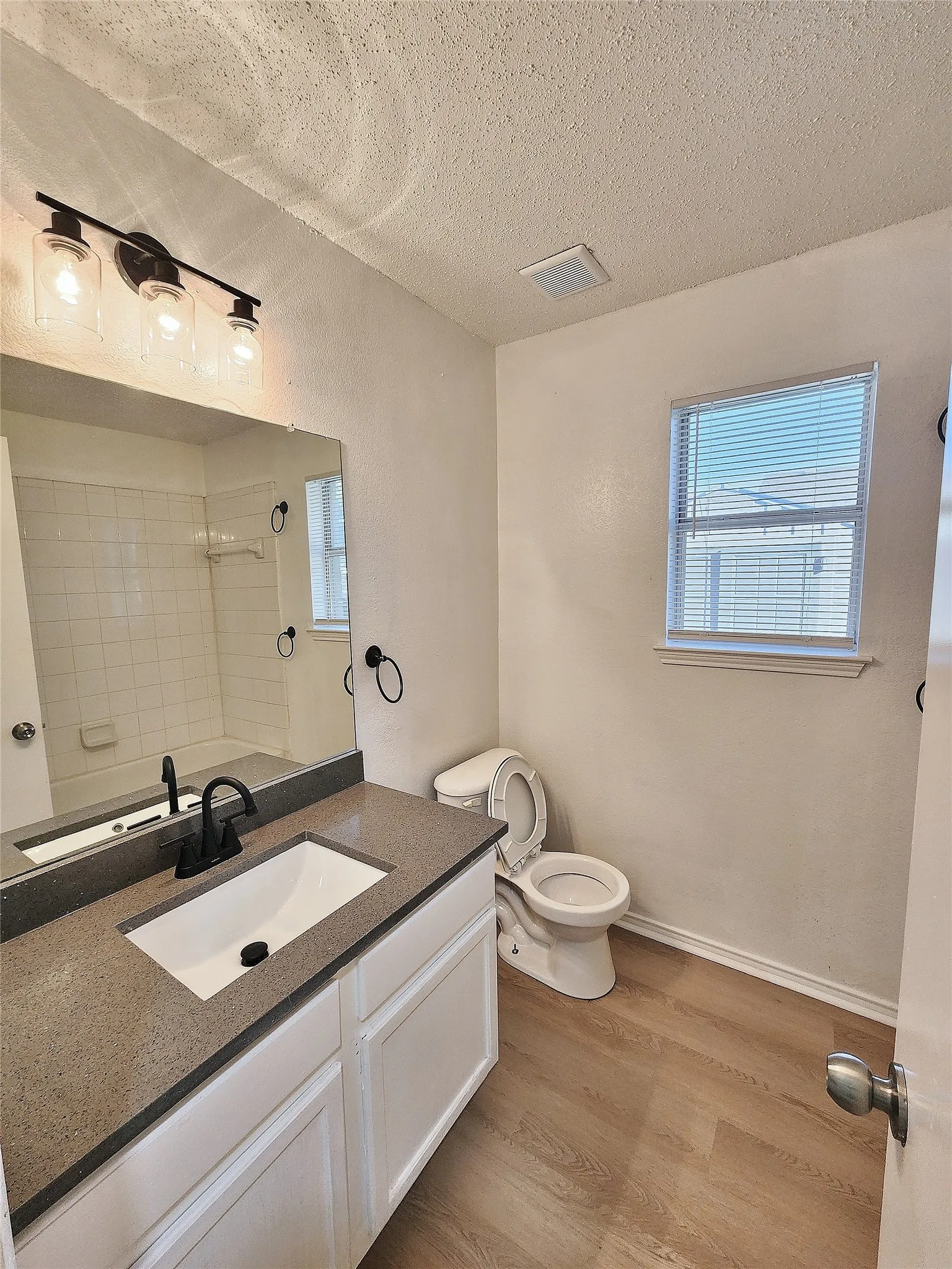 White vanity with a neutral countertop, undermount sink, and matte black faucet