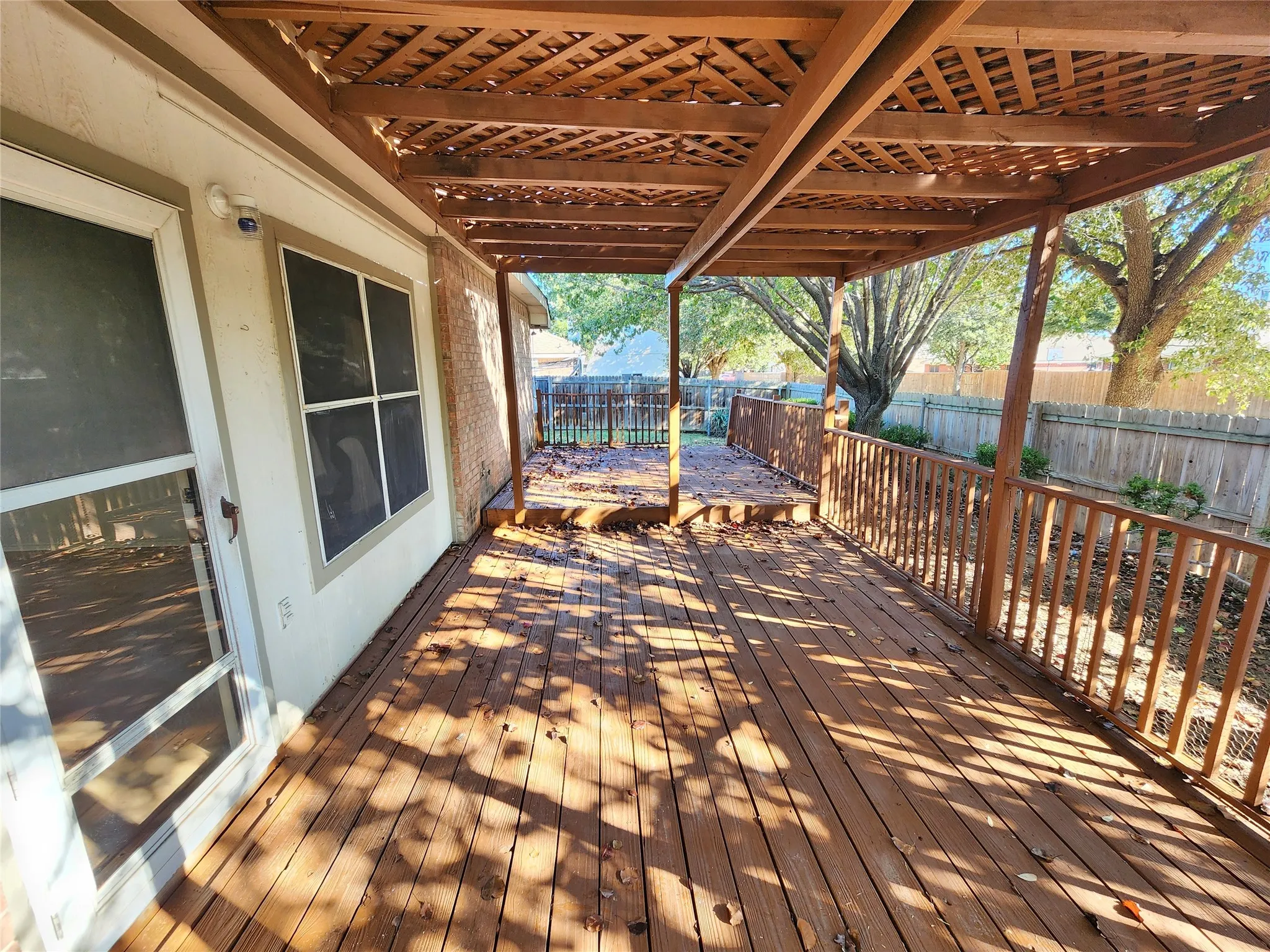 Expansive wood deck with a decorative lattice pergola