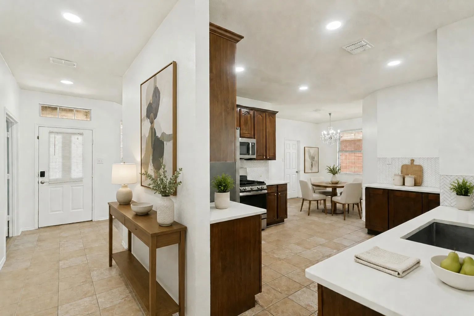 Tile flooring throughout, recessed lighting, white perimeter walls, wood-finish cabinetry, and white countertops