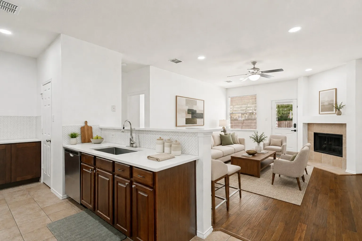 Open concept living area featuring a kitchen with stainless steel appliances, white countertops, and a subway tile backsplash