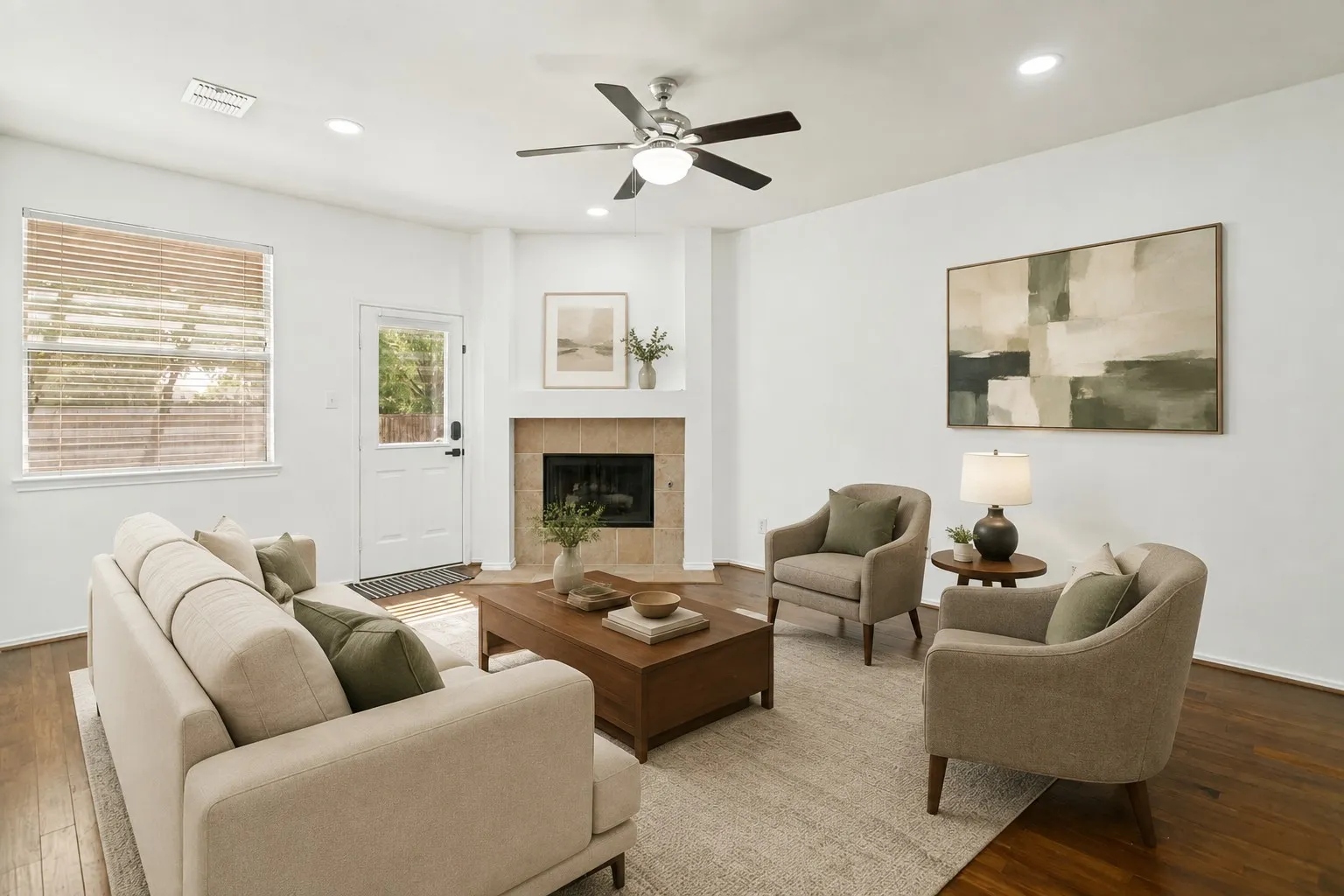 Hardwood flooring, corner fireplace with tile surround, ceiling fan with integrated lighting, recessed lighting, and a white paneled door