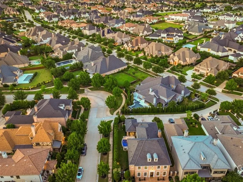 Expansive residential neighborhood featuring a variety of architectural styles, mature landscaping, tree-lined streets, and numerous private swimming pools