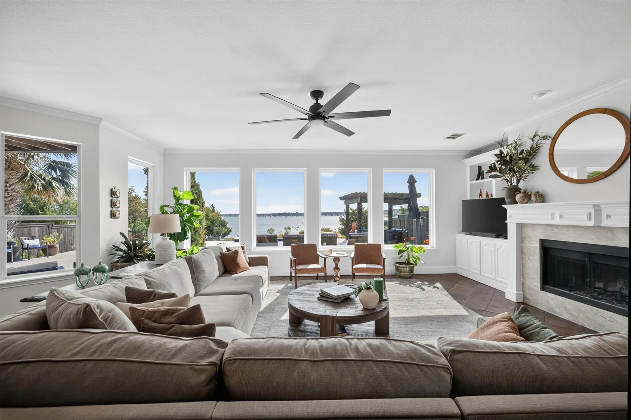 Spacious living area featuring a contemporary ceiling fan, and a built-in media console with storage