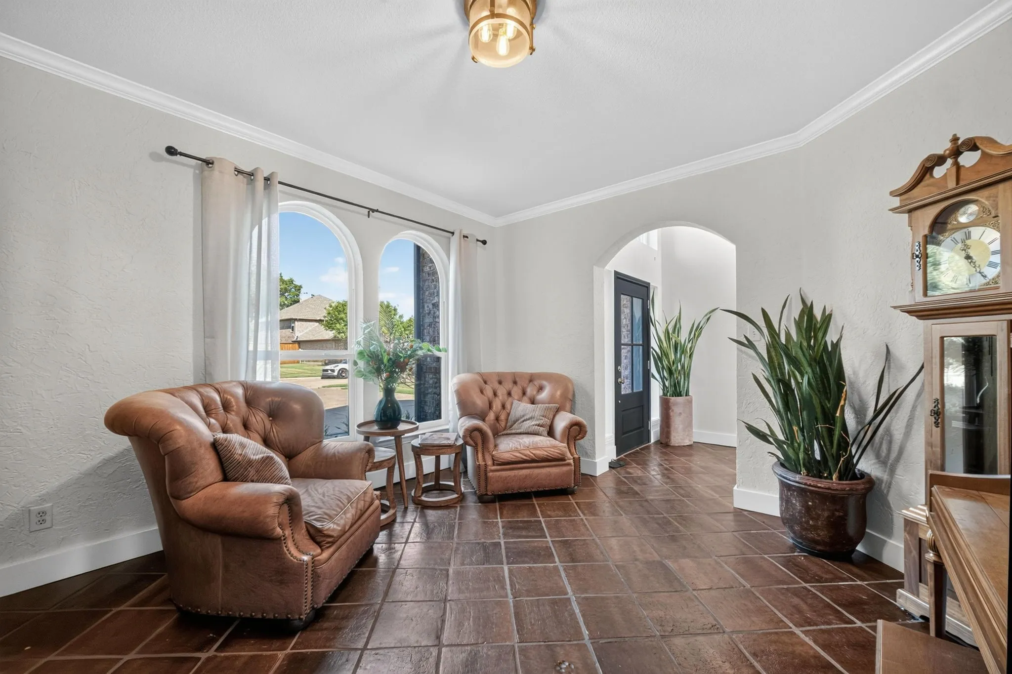 Arch-top windows, beautiful flooring, arched doorway, crown molding, and recessed lighting