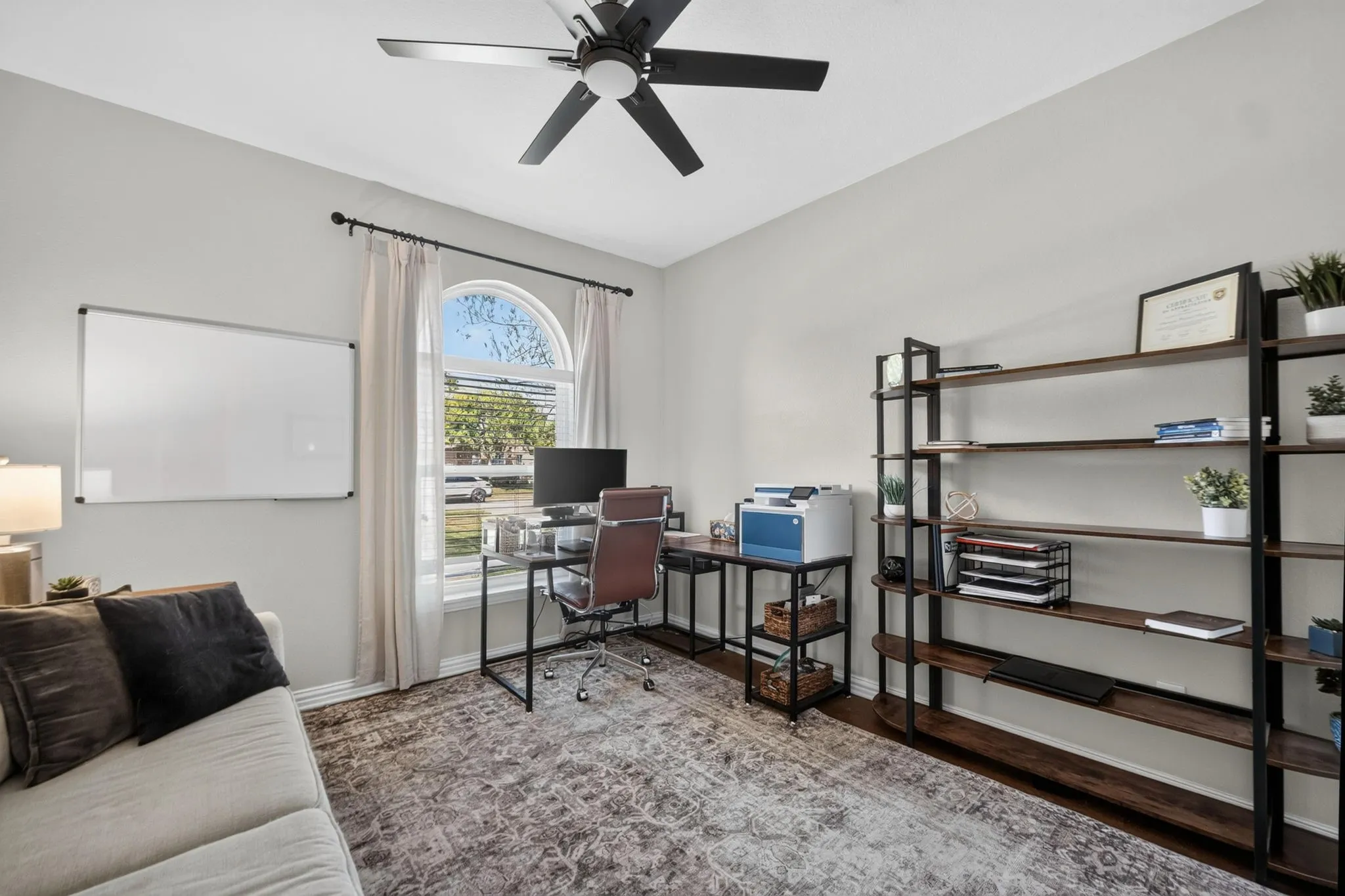 Room featuring a ceiling fan with integrated lighting, an arched window and closet.