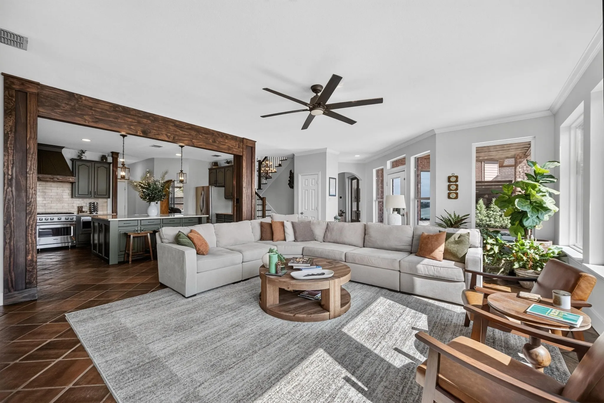 Spacious living area featuring exposed wood beams, and multiple windows