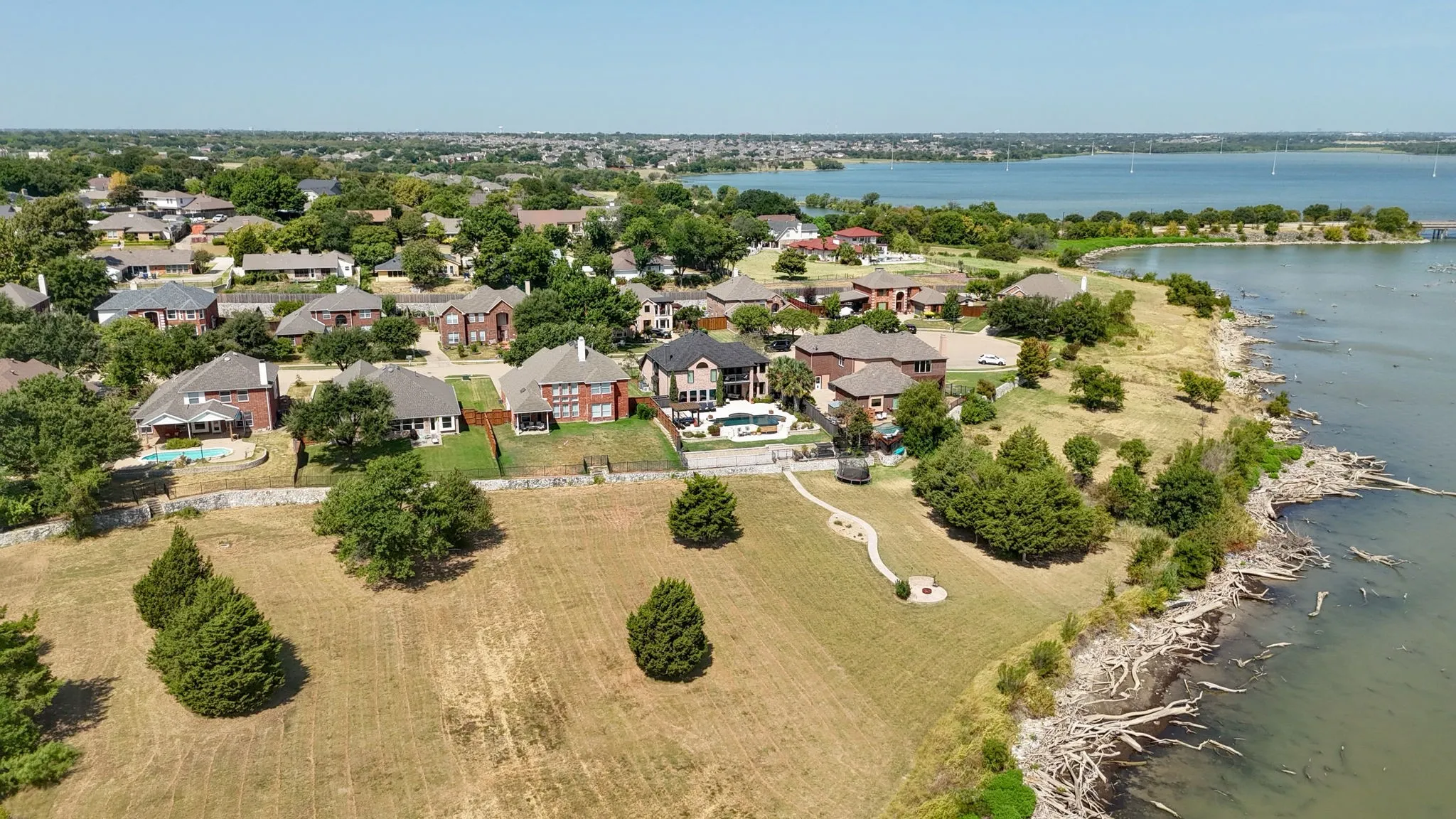 Waterfront residential setting with established landscaping and a large body of water