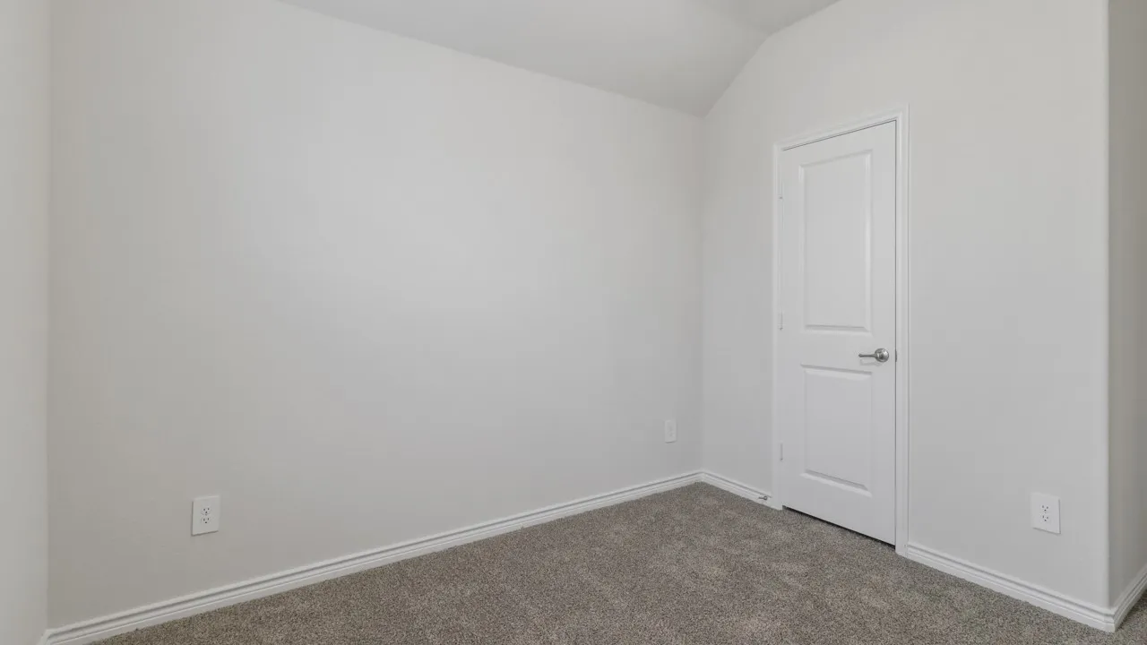 Vaulted ceiling, neutral wall paint, gray carpet flooring, white trim, and a white two-panel door