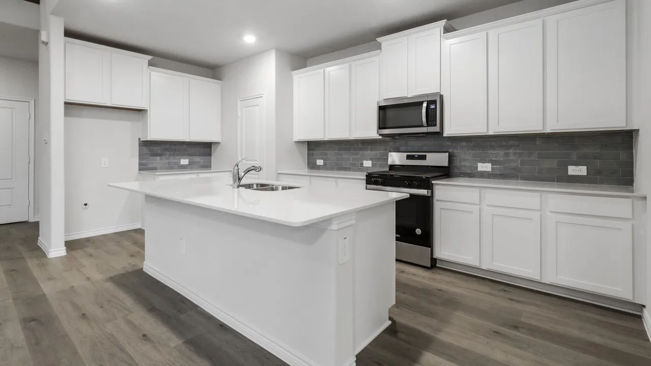 Spacious kitchen featuring white cabinetry, a large kitchen island with an undermount sink, stainless steel appliances, and wood-finish flooring